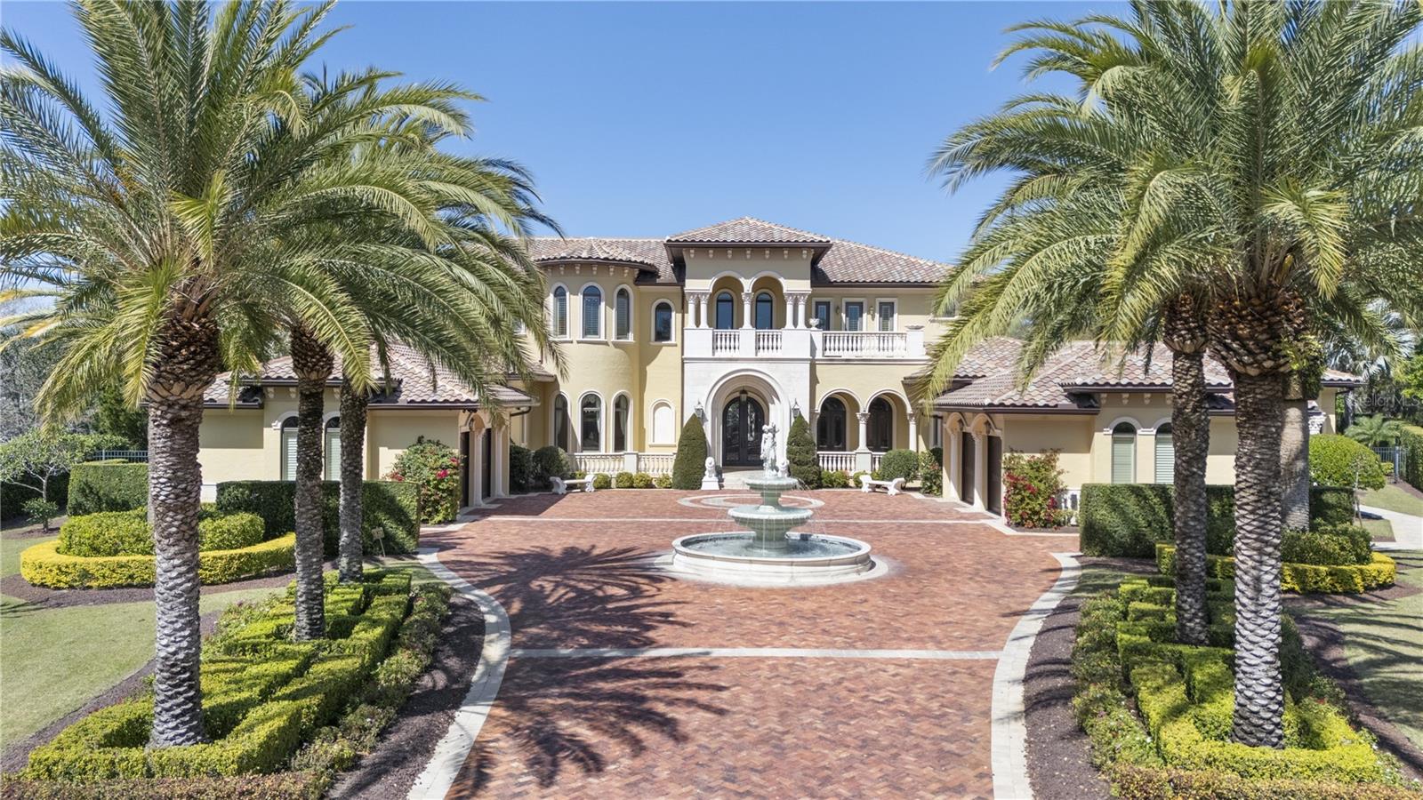 Nestled within a prestigious gated community in the heart of Windermere, this extraordinary estate offers the ultimate in luxury living. The property includes a 1,500 sq ft separate guest house complete with a kitchen, bedroom, and living space, making it perfect for multigenerational families or hosting visitors. The gourmet kitchen is truly a chef's dream, featuring a Viking gas stove, pot filler, carved marble farmhouse sink, Viking refrigerator/freezer, granite countertops, refrigerator drawers, two dishwashers, and a built-in espresso machine. Additional amenities include a wine cellar, mini bar, butler's pantry, and a sauna. For added convenience, an elevator provides access to the upstairs game room and separate media room. The expansive upstairs balconies offer breathtaking views of the meticulously designed outdoor entertainment area, which boasts travertine tile and surround sound. This space includes a large bar and grill, gas fireplace, gas fire pits/balls, and a pergola with a trellis waterfall, all surrounding a stunning 51x25 ft salt-water pool and spa. The Primary suite is a true retreat, complete with a 15x14 exercise room and an 18x16 office featuring custom-built, wall-to-wall cabinetry. The entire first floor is adorned with travertine flooring and decorative frescoes, adding to the home's elegance. The dramatic living room, with 27-foot ceilings and a wall of glass, offers sweeping views of the pool area. The home also features a downstairs guest suite and each of the upstairs bedrooms is equipped with its own walk-in closet and en suite bath, and features private balconies both at the front and rear of the home. The estate also includes a comprehensive sound and security system, featuring a whole-home monitoring system with cameras and separate control rooms for added peace of mind. The property offers a four-car garage (2+2 configuration) and a vast paver driveway, complete with a fountain illuminated by multi-colored lights, all located at the end of a serene cul-de-sac.