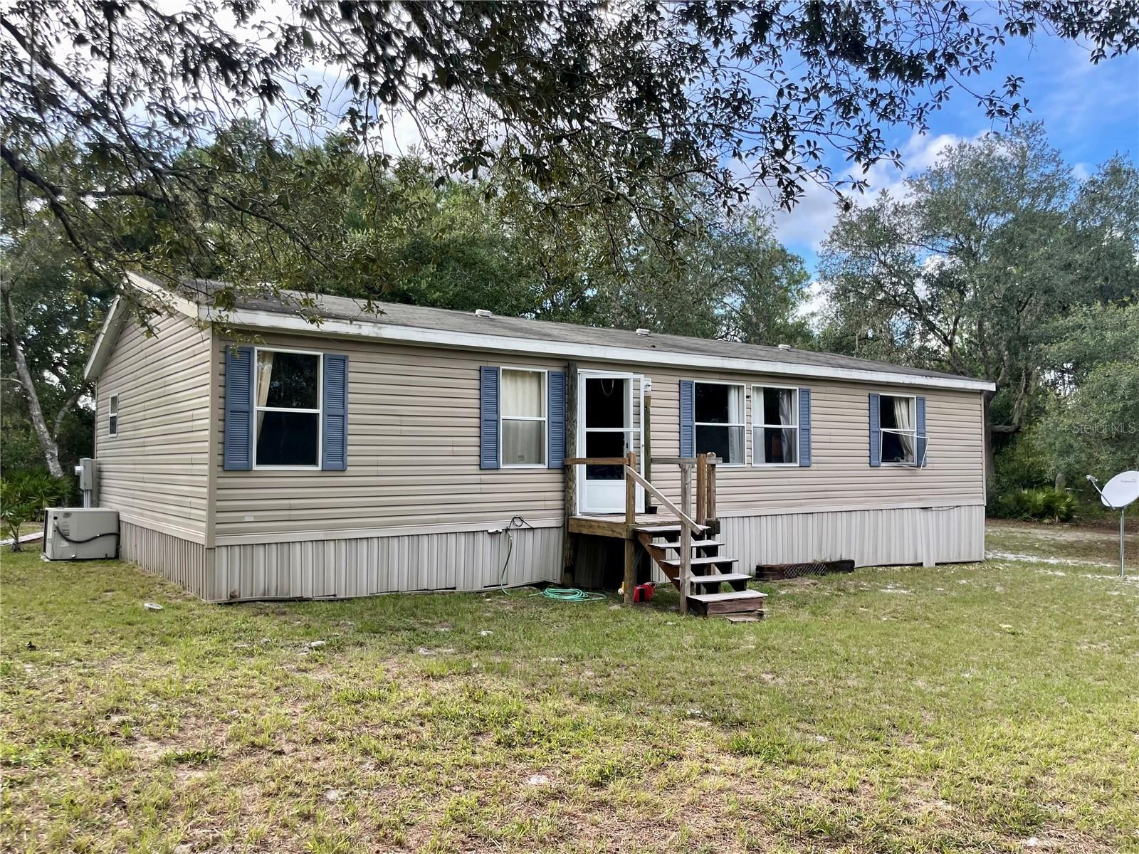 Country Living on 2.52 Acres in Rural Lake County Agriculture Zoning with approximately a 15-minute drive to the town of DeLand. Fully fenced in Property with Native Mature Oak trees throughout, as the land is partially cleared surrounding the home. Property is Zoned Agriculture in Flood Map X. Plenty of Shaded trees for animals or outdoor activities. Enjoy the wooded yard with privacy and abundance of wildlife in the area. There are a couple of shed/outbuildings that would make good storage while working on the property. The Home is a Move in Ready 3 Bedroom 2 Bathroom Doublewide Manufactured Home placed on the property in 2017 with a Split Family Plan, Breakfast Bar and Eating Space in the Kitchen. Handicap Accessible Entrance on the Porch and most of the house is easily accessible by wheelchair. Property is Occupied so must make an Appointment to view the Property and Home. Contact Agent today to make an Appointment. Will look at and consider Offers that will require a Loan and cash offers. NO seller financing available. Must sell outright. Appointment showings only.