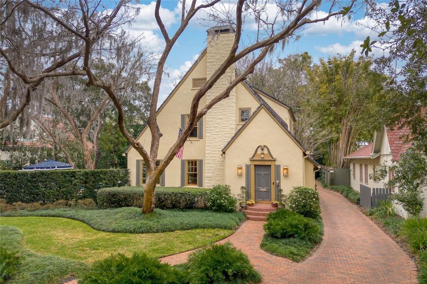Built in 1926, 1226 Golden Lane is truly golden — a timeless Tudor-style residence that has been lovingly maintained and thoughtfully updated while preserving its original character and architectural integrity.  Nestled on a charming brick street, this home immediately captivates with its storybook curb appeal and beautiful landscaping.  Inside, rich wood floors run throughout, complemented by exquisite trim work, custom cabinetry and beautifully refurbished historic windows that flood the home with natural light.  The formal living room features a gas fireplace, creating a warm and inviting gathering space.  A gracious formal dining room showcases built-ins and picture windows overlooking the backyard and saltwater pool — offering a stunning backdrop for entertaining.  Just beyond, the family room includes additional built-ins and large windows, all seamlessly connected to the expanded kitchen for effortless flow.  The fully remodeled kitchen was thoughtfully enlarged and designed for both beauty and function.  Highlights include a gas range with hood, breakfast island bar, generous cabinetry and excellent workspace for cooking and hosting.  A convenient side entrance leads to a practical drop area and one of two half baths on the first floor — perfect for everyday living and the expansive brick driveway provides additional parking.  A beautiful staircase leads upstairs to the 3 bedrooms, office, 2 full baths, including a primary bath added in 2016, and convenient second-floor laundry.  Above the detached 2-car garage, a studio apartment added in 2016 features a private entrance, full bath and kitchenette — ideal for guests, rental income or multigenerational living.  Two additional bonus spaces are a finished basement and large attic, both in the main house, providing additional storage!  Set on an impressive .33-acre lot, the outdoor living is truly exceptional.  Enjoy a saltwater pool, turf play area, abundant brick patio seating, lush landscaping, a fountain and a privacy wall that creates a serene backyard retreat.  With countless thoughtful updates throughout, this remarkable Tudor offers the perfect balance of historic charm and modern convenience in a prime location - adjacent to The Country Club of Orlando, close to The Packing District, downtown Orlando and College Park.  Schedule your private showing of 1226 Golden Lane today — this one is truly golden!