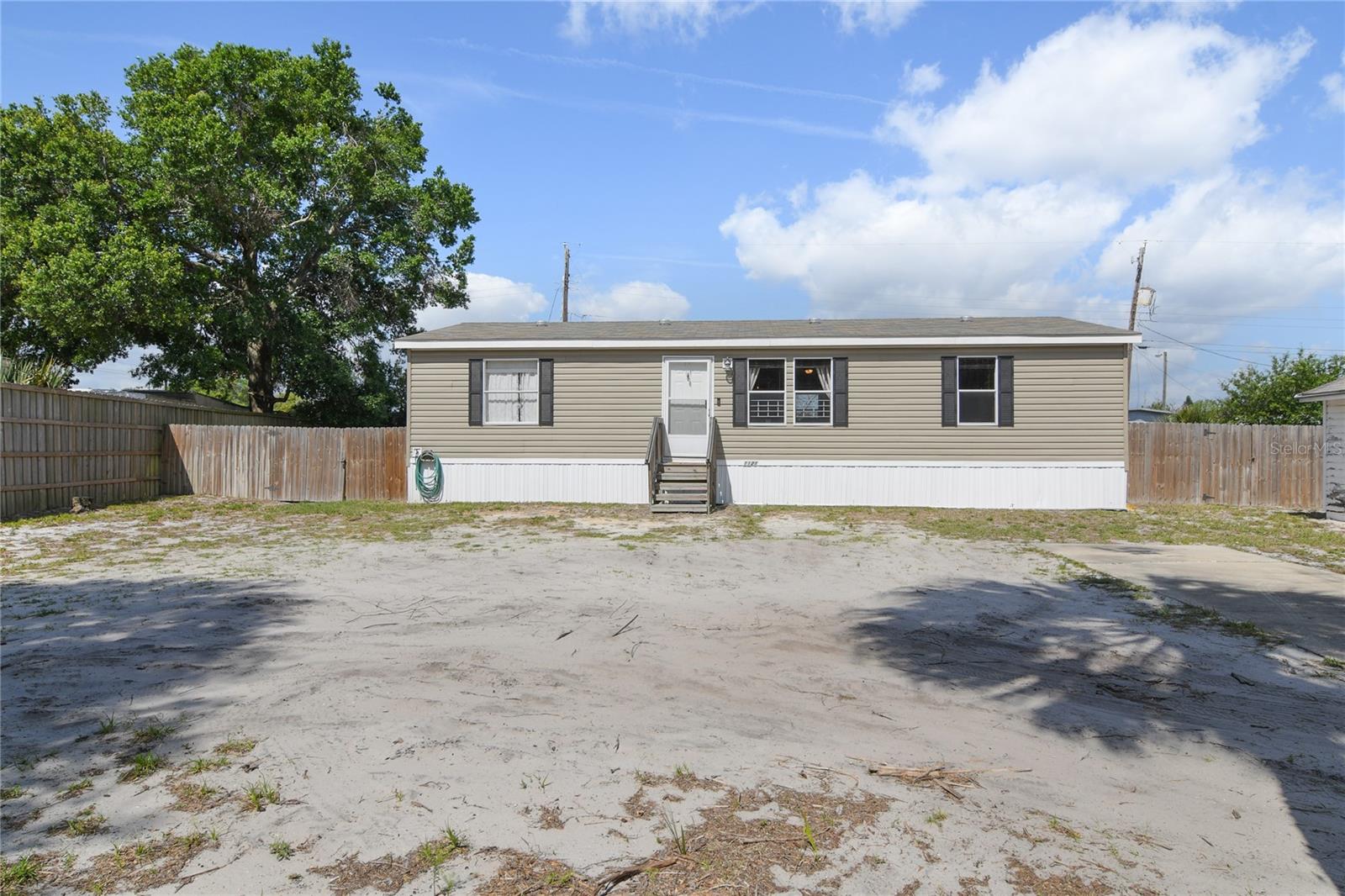 What a unique opportunity for affordable living in unincorporated Mount Dora! Quick access to historic downtown, Tavares and the Harris Chain of Lakes . This 2019 manufactured home offers an open concept and split plan with large fenced yard. Nice upgrades including vaulted ceiling, crown molding and laminate flooring. You'll also enjoy additional storage in the existing shed/garage. Generous laundry/mud room with access to backyard.