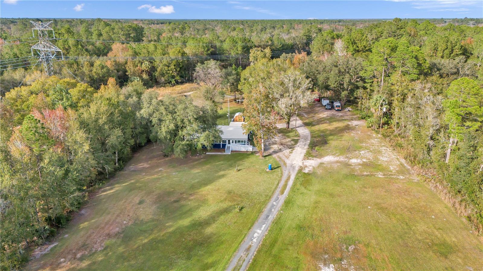 5.4 ACRE LOT WITH 2 WELLS AND 2 SEPTIC SYSTEMS WITH TRAIL FOR RIDING ATV OR UTV'S IN FORT MCCOY! HOME SITS OFF THE ROAD AND PLENTY OF ROOM FOR FUN AND ANIMALS BEING ITS A-1 ZONED AND NOT IN A FLOOD ZONE! METAL ROOF IS 2017, DOUBLE INSULATED WINDOWS AND DOORS 2018,NEW HOT WATER HEATER 2021, 2023 EXTERIOR BLUE PAINT, NEW 2023 POLE BARN, 1ST WELL HAS NEW BLADDER AND NEW ELECTRIC. 2020 WHOLE HOME GENERATOR, HOME FEATURES 3 BEDROOMS AND 2 BATHS(RENOVATED) WITH ADDITIONAL 4TH OPTIONAL BEDROOM OR DEN. WIDE RAMP LEADS TO FULL LENGTH 48 FEET ENCLOSED FRONT PORCH WITH WINDOWS. WALK INSIDE TO SPACIOUS LIVING ROOM WITH VAULTED CEILINGS, TO THE RIGHT OF LIVING ROOM IS LARGE KITCHEN WITH AMPLE COUNTER SPACE AND CABINETS FOR STORAGE AND STAINLESS STEEL APPLIANCES. THROUGH THE KITCHEN IS A MASSIVE LAUNDRY ROOM/STORAGE ROOM AND THIS IS WHERE THE WALK IN PANTRY IS LOCATED. BACK UP TO FRONT OF HOME YOU WILL FIND THE DEN AND 3 BEDROOMS WITH 2 2023 RENOVATED BATHS. ALL BEDROOMS ARE GREAT SIZES WITH THE OWNERS BEDROOM IN FARTHEST CORNER OF HOME WITH VAULTED CEILINGS, DOUBLE FRENCH DOORS OUT TO ENCLOSED PORCH AND ITS OWN MINI SPLIT WHICH MAKES THIS ROOM VERY COMFORTABLE. OWNERS BATH IS BRAND NEW MODERN TILE SURROUND SHOWER, NEW VANITY AND COMMODE. THE 2 SECONDARY BEDROOMS ARE JUST UP THE HALL AND SHARE THE NEWLY UPDATED TILE SURROUND COMBO TUB/SHOWER WITH NEW VANITY AND COMMODE AS WELL! STEP OUTSIDE ONTO BACK PORCH AND YOU WILL SEE NO NEIGHBORS AND PRIVACY GALORE. OUT HERE IS THE 12 X 12 SHED AND 8 X 8 SHED. TO RIGHT YOU WILL FIND THE 20 X 22 NEW POLE BARN. JUST BEYOND POLE BARN THE DRIVEWAY CONTINUES TO BACK 5.4 ACRES TO OPEN CLEARED AREA(MOBILE USED TO BE THERE) THIS IS WHERE THE 2ND WELL AND SEPTIC TANK ARE. HERE YOU COULD PUT A WORKSHOP, ANOTHER HOME. THE OPTIONS ARE OPEN! CLOSE TO TOWN, 90 MINS TO BEACH, ALL KINDS OF HUNTING AND FISHING IN THIS AREA. THERE IS A FAMILY OF DEER THAT FEEDS ON THIS PROPERTY. YOUR ANIMALS. FENCE IT AND BRING THOSE ANIMALS OR WHATEVER SUITS YOUR FANCY! FORT MCCOY HAS ALL YOU NEED TO LIVE THE GOOD LIFE!