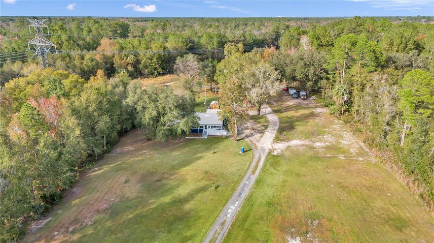 5.4 ACRE LOT WITH 2 WELLS AND 2 SEPTIC SYSTEMS WITH TRAIL FOR RIDING ATV OR UTV'S IN FORT MCCOY! HOME SITS OFF THE ROAD AND PLENTY OF ROOM FOR FUN AND ANIMALS BEING ITS A-1 ZONED AND NOT IN A FLOOD ZONE! METAL ROOF IS 2017, DOUBLE INSULATED WINDOWS AND DOORS 2018,NEW HOT WATER HEATER 2021, 2023 EXTERIOR BLUE PAINT, NEW 2023 POLE BARN, 1ST WELL HAS NEW BLADDER AND NEW ELECTRIC. 2020 WHOLE HOME GENERATOR, HOME FEATURES 3 BEDROOMS AND 2 BATHS(RENOVATED) WITH ADDITIONAL 4TH OPTIONAL BEDROOM OR DEN. WIDE RAMP LEADS TO FULL LENGTH 48 FEET ENCLOSED FRONT PORCH WITH WINDOWS. WALK INSIDE TO SPACIOUS LIVING ROOM WITH VAULTED CEILINGS, TO THE RIGHT OF LIVING ROOM IS LARGE KITCHEN WITH AMPLE COUNTER SPACE AND CABINETS FOR STORAGE AND STAINLESS STEEL APPLIANCES. THROUGH THE KITCHEN IS A MASSIVE LAUNDRY ROOM/STORAGE ROOM AND THIS IS WHERE THE WALK IN PANTRY IS LOCATED. BACK UP TO FRONT OF HOME YOU WILL FIND THE DEN AND 3 BEDROOMS WITH 2 2023 RENOVATED BATHS. ALL BEDROOMS ARE GREAT SIZES WITH THE OWNERS BEDROOM IN FARTHEST CORNER OF HOME WITH VAULTED CEILINGS, DOUBLE FRENCH DOORS OUT TO ENCLOSED PORCH AND ITS OWN MINI SPLIT WHICH MAKES THIS ROOM VERY COMFORTABLE. OWNERS BATH IS BRAND NEW MODERN TILE SURROUND SHOWER, NEW VANITY AND COMMODE. THE 2 SECONDARY BEDROOMS ARE JUST UP THE HALL AND SHARE THE NEWLY UPDATED TILE SURROUND COMBO TUB/SHOWER WITH NEW VANITY AND COMMODE AS WELL! STEP OUTSIDE ONTO BACK PORCH AND YOU WILL SEE NO NEIGHBORS AND PRIVACY GALORE. OUT HERE IS THE 12 X 12 SHED AND 8 X 8 SHED. TO RIGHT YOU WILL FIND THE 20 X 22 NEW POLE BARN. JUST BEYOND POLE BARN THE DRIVEWAY CONTINUES TO BACK 5.4 ACRES TO OPEN CLEARED AREA(MOBILE USED TO BE THERE) THIS IS WHERE THE 2ND WELL AND SEPTIC TANK ARE. HERE YOU COULD PUT A WORKSHOP, ANOTHER HOME. THE OPTIONS ARE OPEN! CLOSE TO TOWN, 90 MINS TO BEACH, ALL KINDS OF HUNTING AND FISHING IN THIS AREA. THERE IS A FAMILY OF DEER THAT FEEDS ON THIS PROPERTY. YOUR ANIMALS. FENCE IT AND BRING THOSE ANIMALS OR WHATEVER SUITS YOUR FANCY! FORT MCCOY HAS ALL YOU NEED TO LIVE THE GOOD LIFE!
