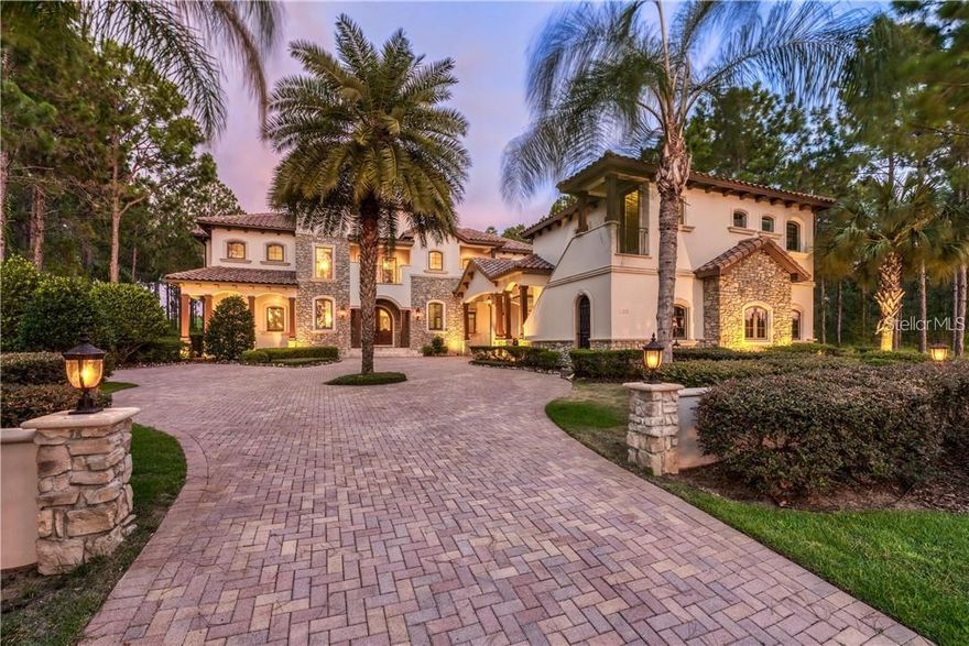 Welcome to this extraordinary custom estate in Bella Collina, Central Florida’s premier private, guard-gated golf community. Perfectly positioned on an expansive homesite framed by mature trees and lush landscaping, this grand residence blends timeless architecture with modern luxury and exceptional privacy.

From the moment you arrive, the impressive stone elevation and stately presence set the tone for what awaits inside. Ornate double doors open to a dramatic two-story atrium, introducing oak plank-style flooring throughout the main level and refined architectural details including custom oak panels, pillars, and designer millwork.

The expansive chef’s kitchen is a true showpiece, featuring a six-burner Wolf range, dual Sub-Zero refrigerator/freezers, prep bar, hidden butler’s pantry, and adjoining laundry room (the first of two). The kitchen flows seamlessly into the generous living area, where 90-degree mitered sliding glass doors and a massive picture window frame breathtaking views of one of the finest resort-style pool environments in the community.

The first floor also offers a guest suite and a fully equipped entertainment/media room with wet bar and direct access to the pool deck—ideal for hosting gatherings of any scale. A full-home Crestron automation system enhances convenience, comfort, and control throughout.

Upstairs, accessible by a secondary staircase off the dining area (and elevator service), you’ll find a versatile flex room, private office, two additional guest bedrooms, a second laundry room, and the secluded owner’s retreat. The primary suite is a true sanctuary, featuring exposed beams, tray ceiling detail, custom baseboards, private balcony overlooking the pool, and an expansive spa-inspired bath with separate water closets, spa tub, dual vanities, and custom oak closet systems.

Outdoor living rivals the finest luxury resorts. The custom-designed pool showcases travertine pavers, multi-person spa, swim-up seating, sun shelf, and elegant fountain features. All pool equipment has just been completely replaced, offering peace of mind and enhanced efficiency for years to come. A large fire pit gathering space, fully equipped summer kitchen with custom hood, and a private courtyard with pergola, fireplace, and television create multiple venues for entertaining year-round.

Additional highlights include:

Elevator servicing multiple levels

Two double garages with generous parking

Above-garage apartment with full kitchen and bath featuring engineered wood flooring.

Mature landscaping providing exceptional privacy

Residents of Bella Collina enjoy a lifestyle unlike any other, with a Nick Faldo-designed championship golf course, resort-style pool, fitness center with complimentary classes, tennis and pickleball courts, full-service spa, and multiple dining venues - all just minutes from Montverde Academy and major highways.

This is a rare opportunity to own a truly grand custom estate designed for luxurious everyday living and unforgettable entertaining. A private showing is highly recommended to fully appreciate everything this exceptional home provides.

Seller will Defer $40,000 Sports Membership Deposit at Closing.