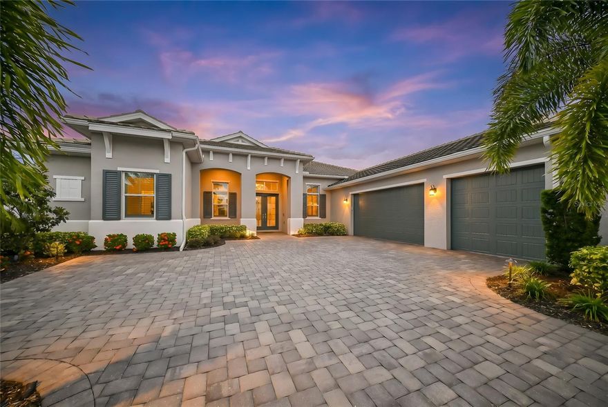 Nestled behind the gates of The Isles at Lakewood Ranch, this exceptional highly upgraded Captiva Collection residence blends refined luxury with effortless Florida living on an oversized 80’ x 150’ homesite. Built in 2020, the thoughtfully designed home offers 3 bedrooms, 3 full baths, a powder room, office/flex space, and nearly 2,900 square feet of beautifully curated interiors in the heart of Lakewood Ranch.
From the moment you enter, elevated finishes and custom details set the tone — including hardwood floors in the office and primary suite, coffered ceilings with decorative beams, crown molding, plantation shutters, upgraded lighting fixtures, and a built-in credenza in the great room. Pocket sliding glass doors create a seamless connection to the expansive lanai, where resort-style outdoor living takes center stage.
The custom pool features travertine marble decking, a sun shelf, and a Paramount self-cleaning system, all framed by lush professional landscaping and outdoor lighting. The outdoor kitchen is equally impressive with granite counters, backsplash, and dedicated cabinetry for effortless entertaining under the Florida sky.
The gourmet kitchen offers upgraded cabinetry and counters, double pantry storage, wine refrigerator, and generous gathering space overlooking the great room and pool. The luxurious primary suite includes a standalone soaking tub, custom cabinetry, and spa-inspired finishes.
Additional highlights include hurricane impact glass throughout, whole-house gutters with underground pop-ups, radiant barrier insulation, Kohler whole-house generator with transferable 10-year warranty, Mitsubishi mini-split system in the garage, water softener and charcoal filtration system, surround sound and home WiFi enhancements, storage cabinetry and workbench in the garage, and new LG washer and dryer (2026).
Perfectly positioned near world-class golf, dining, shopping, and the vibrant lifestyle amenities that define Lakewood Ranch, this home is polished, private, and designed for living beautifully.