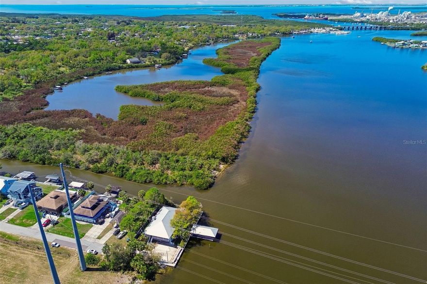 Welcome to a spectacular waterfront retreat on the Alafia River, where privacy, breathtaking views, and exceptional boating access come together to create the ultimate Florida lifestyle. Enter through your private gated entrance and discover a serene riverfront property perfectly positioned on the wide section of the Alafia River between Hwy 41 and I-75, offering sweeping water views and direct access to adventure.
This 4-bedroom, 3-bathroom home is thoughtfully designed to capture the beauty of the river from nearly every space. The home features two levels of living, with the lower level constructed of solid concrete block and the upper level crafted in cedar, blending durability with timeless character. Enjoy sunrise and sunset views from two expansive 40x13 screened porches, or unwind from the covered dock and extended open fishing and sun deck overlooking the water.
Inside, the open floor plan is highlighted by a dramatic cathedral ceiling in the great room and a stunning stone fireplace, creating a warm and inviting gathering space. The chef inspired kitchen is designed for both entertaining and everyday living, showcasing granite countertops, new cabinetry, a large center island, tile backsplash, and quality stainless-steel appliances. French doors lead directly to the screened porch, making indoor-outdoor living effortless.
The owner’s suite is a true sanctuary, offering peaceful river views. Featuring a huge walk-in closet with built in shelving, a window overlooking the water and a spacious en-suite complete with a water closet, dual granite vanities, a Jacuzzi soaking tub and a large ‘custom tiled’ walk-in shower.
The oversized laundry room adds both function and convenience, featuring abundant cabinet storage and a granite countertop workspace, making everyday tasks easy and organized.  Two additional bedrooms are thoughtfully positioned for privacy.
The lower level features beautiful Saltillo tile flooring, a large family room opening to another screened porch, and a private guest suite with an adjoining spacious room and nearby full bath, making it perfect for visitors, extended family, or flexible living space.
Step outside to your private waterfront playground. The covered dock with electric boat lift and additional swim deck are ideal for launching kayaks and paddleboards or heading out for a boat ride to Tampa Bay and waterfront restaurants. Spend your days fishing, crabbing, or watching dolphins, manatees, and abundant birdlife right from your backyard.
Additional features include gas cooking, smart light switches, double-hung hurricane windows and doors, whole-house water filtration system, tankless gas water heater, dual AC units, LED lighting throughout, 2-inch wood blinds, and generous storage including an air-conditioned storage room.
Conveniently located, you are 10 minutes by boat to Tampa Bay and about 20 minutes to the Sunshine Skyway. By car, you are about 30 minutes to Tampa International Airport, and about 45 minutes to the beautiful Sarasota and Bradenton beaches via I-75.
Situated on a spacious corner lot with room for boats, kayaks, paddleboards, and RV parking, this extraordinary Alafia River waterfront gem offers the perfect balance of luxury, recreation, and tranquility—a rare opportunity to experience the very best of Florida riverfront living.