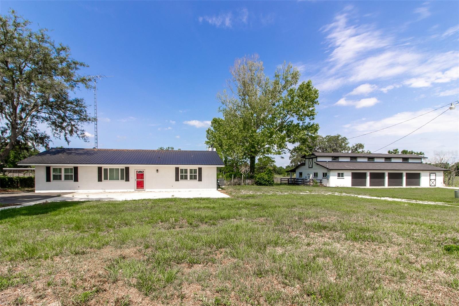 Discover the charm of country living on this 12-acre farm in the heart of the Horse Capital of the World. Back Archers Farm offers a peaceful retreat just minutes from restaurants, shopping, and healthcare facilities. Surrounded by horse farms, this fully fenced property is ideally located—only 2 minutes from SR 200, 15 minutes to the World Equestrian Center, 20 minutes to the Florida Horse Park, and 25 minutes to HITS. Hidden away on a quiet road, the property features an electric gate that opens to a beautifully renovated 3-bedroom, 2-bathroom home. The home includes a cozy fireplace, a remodeled kitchen, new flooring, 2019 AC and windows, and a covered back porch with views of lush pastures. The land boasts 7 paddocks and a round pen, perfect for equestrian use. The centerpiece for horse enthusiasts is the large concrete barn, complete with a wash rack, feed/tack room, an oversized garage workshop, and 6 concrete stalls. This equestrian-ready property is waiting for its new owners. Schedule your showing today!