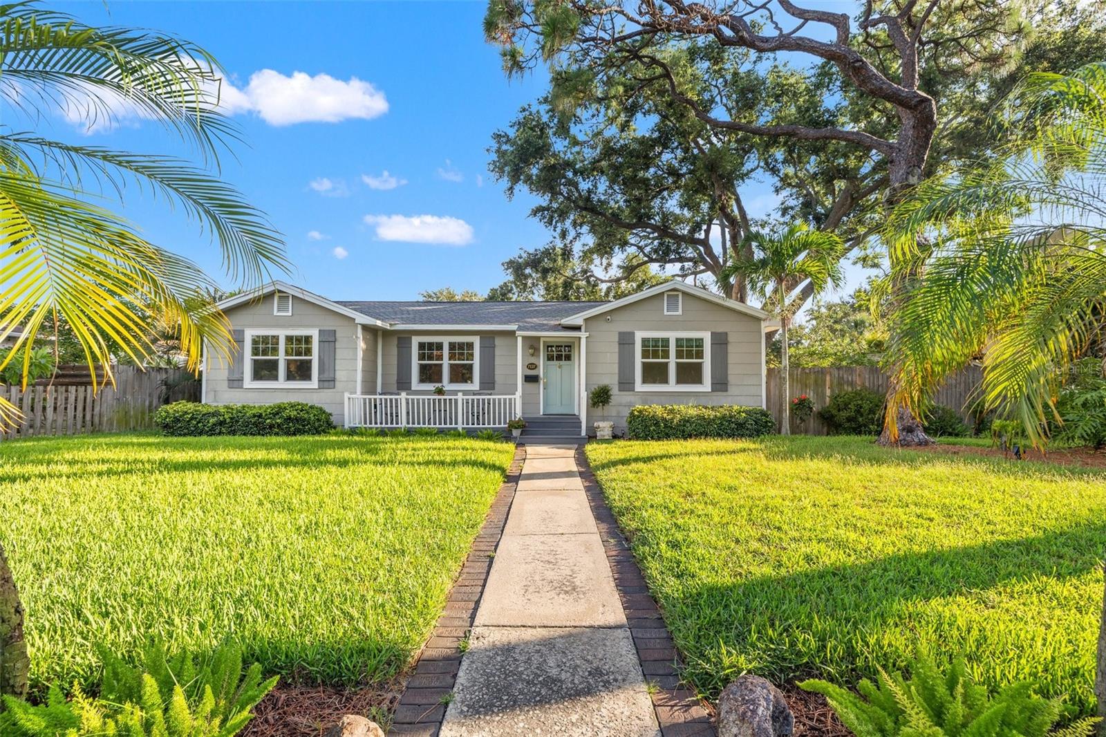 Tucked away in one of South Pasadena’s most well-established neighborhoods, this meticulously maintained ranch-style residence features a perfect blend of classic character and modern updates. Featuring 4 bedrooms, 2.5 bathrooms, and approximately 1,930 square feet of thoughtfully designed living space, this home invites you to enjoy a lifestyle of comfort, convenience, and understated elegance—just minutes from I-275, and the award-winning Gulf beaches. Step inside and feel the warmth of the home’s open concept floor plan, where spaces flow effortlessly for entertaining and everyday living. Original hardwood floors add charm and history to key areas, while brand new carpet and laminate flooring in others ensures a fresh, soft underfoot experience. Vaulted ceilings, crown molding, and shiplap accents lend architectural interest and an elevated sense of style in the kitchen and family room. At the heart of the home caters to both the chef and the avid entertainer. Outfitted with stainless steel appliances, a gas cooktop range, Cambria Quartz countertops, and a center skylight that bathes the space in natural light, the kitchen also includes ample cabinetry, prep space, and open sight lines into the main living and snack bar area. Whether you're hosting friends or preparing a quiet family meal, this space checks all the boxes. The primary bedroom is a serene retreat, privately positioned and thoughtfully updated with new carpet, a spacious walk-in closet, and a beautifully appointed ensuite bathroom. The remaining bedrooms are generous in size and features flexibility for family and guests. The fourth bedroom is ideally suited as a dedicated home office, complete with French door access and a spacious closet—perfect for productivity without compromising style. Additional features include custom built-in shelving in the family room gas fireplace, hurricane impact windows throughout, and updated lighting that creates a warm, welcoming ambiance in every room. There's also an attached 1-car garage for secure parking and features a utility sink & built-in storage and the added benefit of rear alley access for ease and privacy. Outdoors, a fenced backyard provides a tranquil escape. Enjoy sunset dining or morning coffee on the wood deck, or bring your hobbies to life in the detached workshop/storage space—fully equipped with electric and ready to serve as a studio, gym, or creative haven. Lush landscaping and mature trees create lots of shade and privacy, while craftsman-style window trim on the interior reinforces the home’s commitment to quality and craftsmanship. Situated on classic brick roads, this home offers more than just curb appeal—it delivers a coveted lifestyle. Enjoy easy access to the Pinellas Trail, vibrant shopping districts, local dining, and a short drive to downtown St. Petersburg’s waterfront arts and entertainment scene.