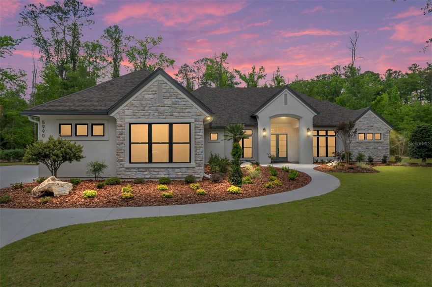 2026 Parade of Homes! Introducing this breath taking home crafted on a beautifully wooded 1.56 acre lot in The Reserve at Millhopper. Meticulously designed and constructed by Barry Bullard Homes, this remarkable residence spans 3735 square feet, offering a seamless open concept floor plan complemented by captivating glass elements throughout. With a thoughtfully planned layout, this home presents 4 bedrooms with 4 ensuite bathrooms and an additional guest half bath, a study, and a versatile flex room with a wet bar. The great room stands out with 12” ceilings with decorative wood beams . A gas fireplace with a custom precast stone surround creates a cozy ambiance, while built-in cabinets provide both functionality and style. The heart of the home is every culinary enthusiast's dream kitchen. It boasts a sprawling island and top-of-the-line KitchenAid package including 36” Dual Fuel range, custom made metal vent hood, 36” counter depth refrigerator, dishwasher, microwave drawer, and wine refrigerator. A large walk-in  butler’s pantry with prep sink and generous storage shelving completes the kitchen package. The kitchen great & dining rooms extend seamlessly outdoors through a stack of sliding glass doors, leading to a spacious outdoor entertaining area. This enchanting patio is fully paved and offers a beautiful pool with a sun shelf, and a mesmerizing water feature. A large lanai features with electric powered roll down screens features a summer kitchen with a built-in grill and sink. The master suite serves as a true sanctuary, encompassing two walk-in closets, dual sink vanity, a sizable walk-in shower, and a freestanding soaking tub for indulgent relaxation. Energy efficiency takes center stage in this home, thanks to its cutting-edge features including spray foam insulation, tankless hot water heaters, electric heat pump HVAC system split into 2 zones for high-efficiency heating and cooling, LED recessed cans, and vinyl insulated low E windows. Elevating the interior to new heights, this residence showcases upgraded finishes throughout. Luxury Vinyl Plank flooring graces every room except the bathrooms, clean modern interior trim adds a touch of elegance, cove crown molding adorns the common areas and master suite. Enhanced plumbing and lighting fixtures further amplify the home's luxurious appeal. The laundry center offers convenience with its practical folding top, and a 3-car garage adds ample space for vehicles and storage. Externally, the home is adorned with smooth finish stucco and decorative stone accents. The property is situated on a meticulously landscaped 1.56-acre lot. In its entirety, this newly constructed masterpiece within The Reserve at Millhopper epitomizes the pinnacle of luxury living, showcasing remarkable design features and modern conveniences that cater to your every desire.