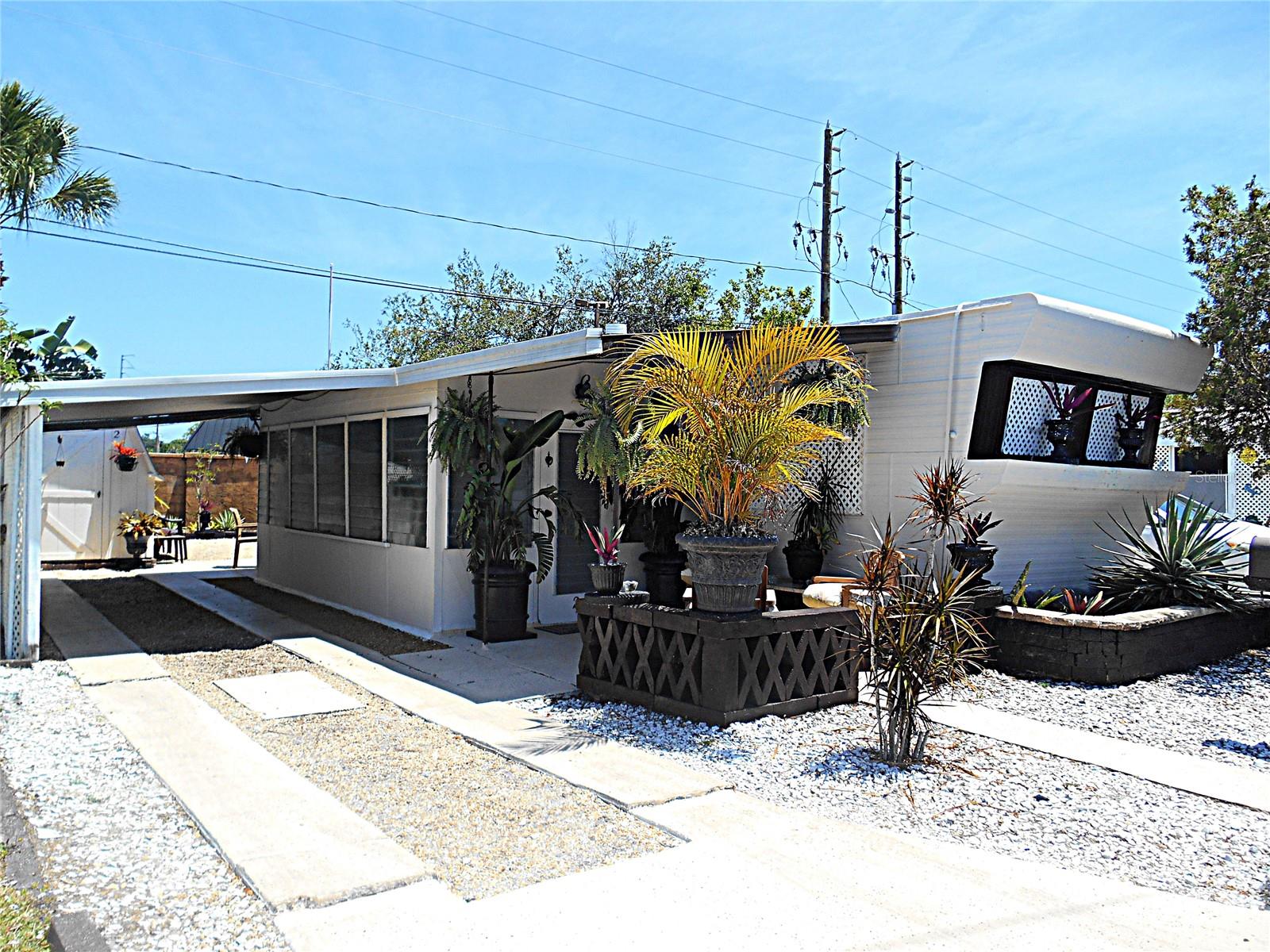 Your affordable slice of paradise awaits in this charming, fully furnished mobile home that provides a private large yard! Situated on a very desirable end unit, this property features 2 bedrooms, 1 bathroom, and a wonderful screened 18' x 9' Florida room – your perfect spot for relaxing and extending your living space! You'll appreciate the convenience of dedicated parking for two vehicles, complete with a covered carport. A large exterior shed provides ample storage space. Inside, enjoy modern comforts such as newer windows, upgraded electrical and newer appliances, including a gas stove. Added perks include a water filtration system, a space-saving combination washer & dryer, and a surround sound TV for entertainment. The freshly painted exterior and new roof over complete this move-in-ready gem. Last but not least, the private side and back yard offer a fantastic extension of your living space, perfect for hosting BBQs and cultivating your green thumb. Located just 15 minutes from the tranquil beaches, Eagles Nest is a 55 and over cooperative with a low monthly fee of only $177/ month which includes water, sewer, trash and lawn maintenance! If you're an active adult, you'll be thrilled that you are nestled across from the 133 acre Walter Fuller Park and steps away from walking trails, a pool, picnic areas, a dog park, basketball / tennis/ pickleball courts and several festival & sporting events, not to mention near a plethora of restaurants, retail stores, the Tyrone Square Mall, the Pinellas Trail and much much more! Bring your furry friend to enjoy Florida living as 2 pets (under 30 lbs.) are permitted. Perfect for full time living and/ or a vacation home, don't delay & see this today!