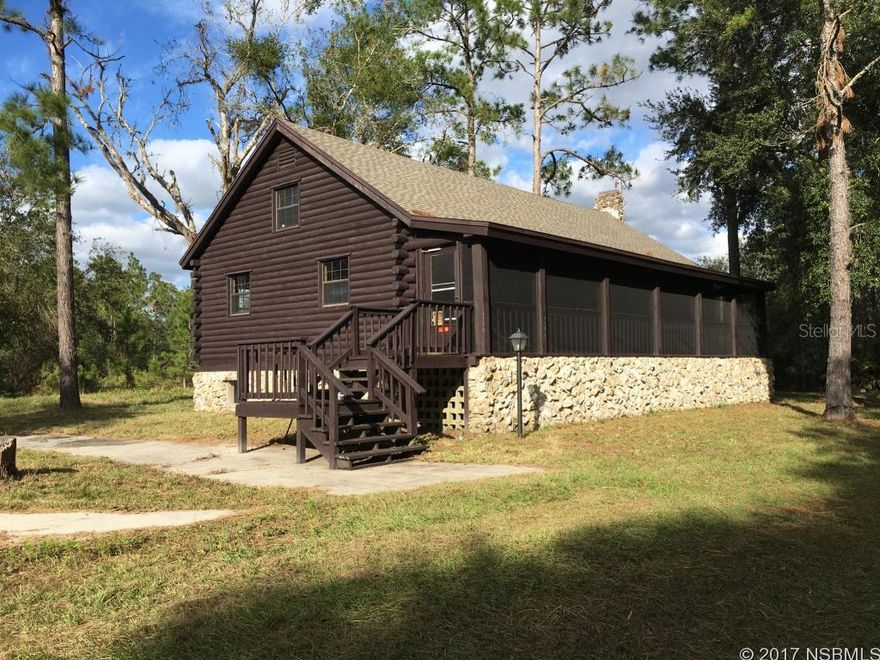 Unique Log Cabin on 10 Acres in New Smyrna Beach. Original owner built this 3-Bdrm, 2-Bath Home with Large Loft which could be used as 4th Bedroom or Family Room. Huge Stone Fireplace, Log Beams and Walls add to Charm and Cozy Atmosphere of this Home. Beautiful Stone covers the 6-block high foundation with unfinished bsmt area and storage. A Screened Porch along the entire length of home provides Amazing View of the Various Mature Trees & Plants on the Property.  New Roof 2017, plus new well pump & water heater. Termite & Mold Bonds. Handicap access.  Bring your Horses - you are Next Door to the 8,000-acre Deep Creek Preserve with biking, hiking, etc.  Enjoy the Quiet Beauty, Privacy and Wildlife visits while living in this Country Home. All this & only a few miles to the Fabulous NSB Beach, Shops and Restaurants.  Life is Good Here!
