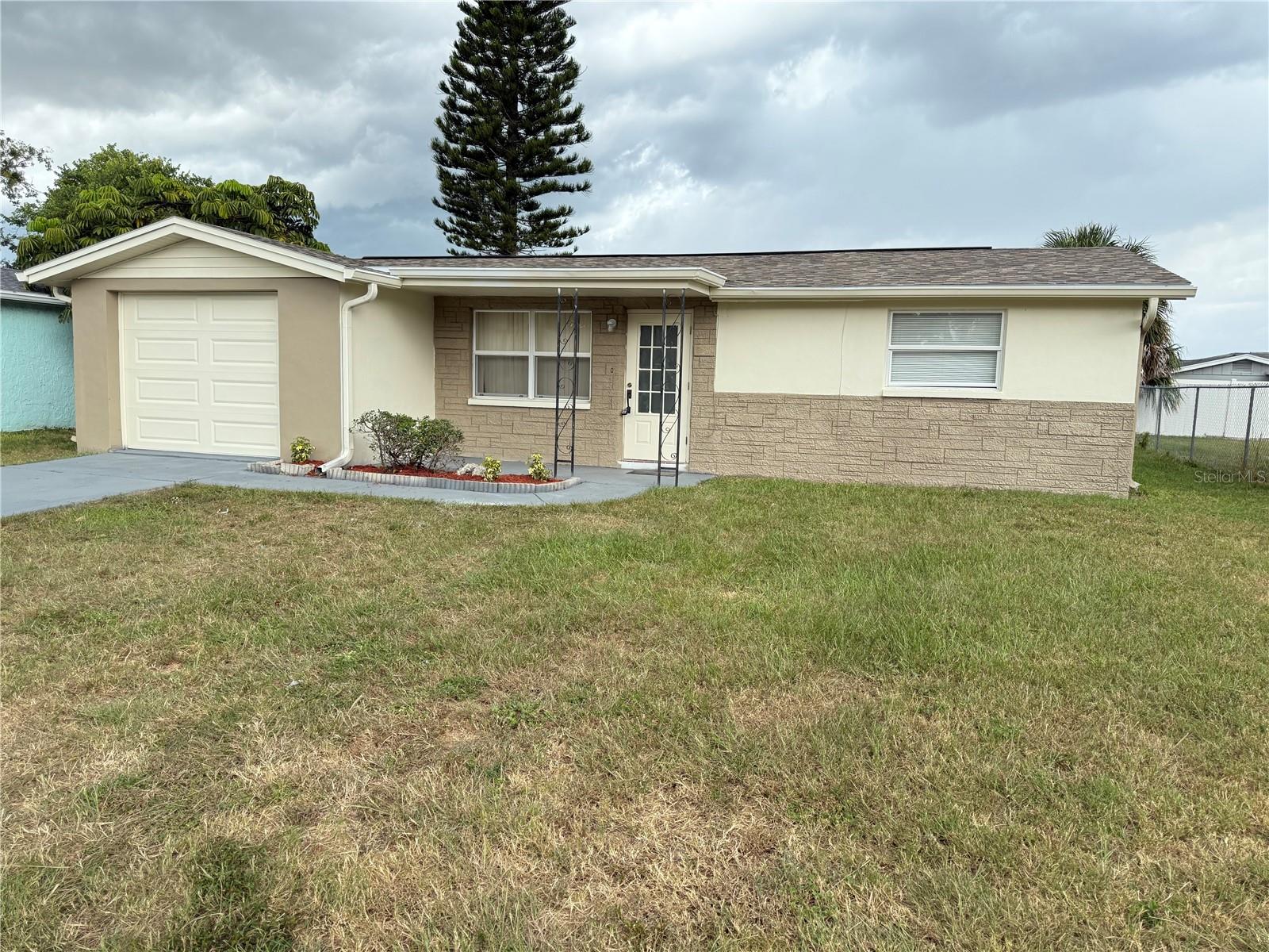 Another affordable block home. Remodeled, updated and move in ready. Home has new roof, New garage door/opener, new flooring, new stainless appliances, updated Kitchen and Bath room. Water heater, Windows and doors are newer and inside/outside of home are freshly painted. This property has a rear covered screen porch, French door, and large fenced yard. The location and neighborhood looks great with easy access to US 19 Highway, shopping centers and Health facilities. No HOA or CDD fee to worry about. Property does not require lender flood insurance