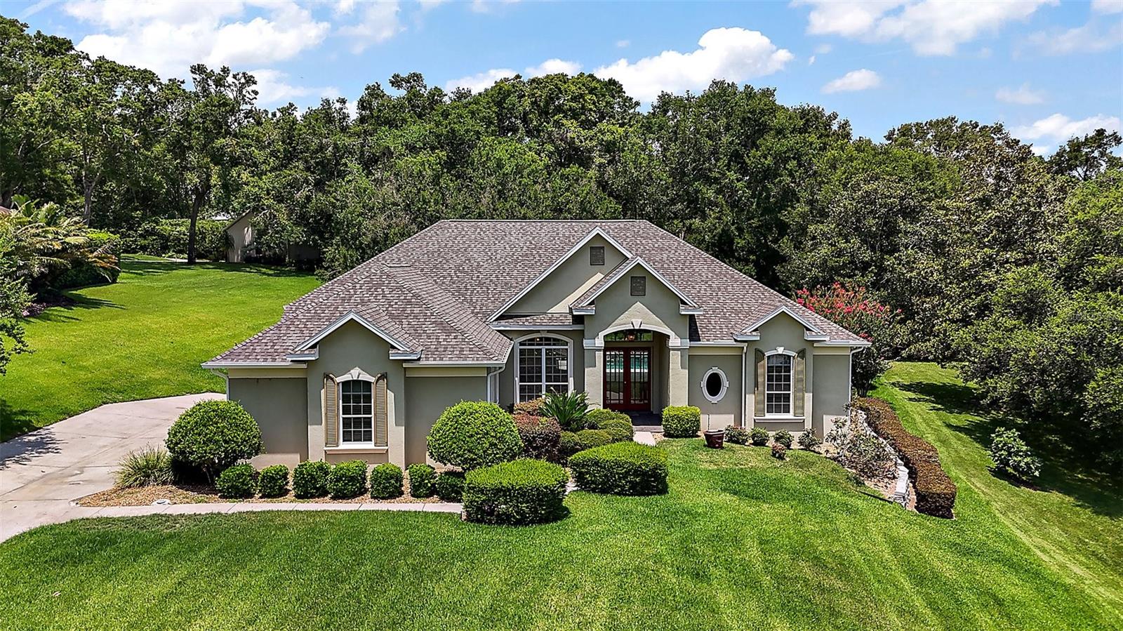 EXQUISITE 3-BEDROOM POOL HOME IN MT. DORA'S PRESTIGIOUS CHESTERHILL ESTATES Welcome to your serene retreat in one of Mount Dora’s most sought-after communities—Chesterhill Estates. Nestled among mature trees on an expansive 1.04-acre lot, this tranquil enclave offers peace, privacy, and proximity, less than 2 miles to the heart of charming, historic downtown. Whether you’re strolling or cycling, you're just minutes from all the treasures this idyllic town offers. Spend the afternoon at Gilbert Park's popular playground, launch your boat from the public ramp or full-service marina, and enjoy scenic views of the iconic Mount Dora lighthouse. Explore the Harris Chain of Lakes or browse eclectic boutiques and art galleries. Grab lunch at an outdoor cafe, then treat yourself to something sweet from a local bakery or ice cream shop. At the end of the day, return to your peaceful haven—where comfort and beauty welcome you home. Curb appeal abounds with a freshly painted stucco exterior in warm, earthy tones, arched windows, a covered front entry, and a brand-new roof (installed in June 2025). A long driveway leads to a side-entry 2-car garage, while a charming paver walkway guides you to elegant double glass front doors. Inside, the open and airy floor plan features soaring ceilings, crown molding, and stylish tile flooring throughout the main living areas. A stately column defines the formal living room, where an expansive sliding glass door offers stunning views of the pool, making it perfect for entertaining. The adjacent dining room is equally impressive, featuring double tray ceilings, a statement chandelier, and an oversized window that allows for abundant natural light. At the heart of the home is a spacious kitchen designed for both functionality and style. Enjoy custom wood cabinetry, granite countertops, a tumbled tile backsplash, a walk-in pantry, a built-in desk or coffee station, stainless steel appliances (including a French door fridge), a solar tube skylight, and a generous center island with a prep sink. Casual meals are a joy at the breakfast bar or in the kitchen’s dining nook, both offering panoramic views of the pool. The inviting family room, with built-in shelving and triple glass sliders, opens to the screened lanai, creating an ideal indoor-outdoor living space. The split-bedroom floor plan ensures privacy, with a relaxing owner’s suite featuring plush carpet, crown molding, pool access, and large windows that fill the room with light. The ensuite bath offers two separate vanities, a tiled walk-in shower, a deep soaking tub, and a spacious walk-in closet. Bedrooms 2 and 3 are bright and comfortable, sharing a well-appointed full bath with a tub/shower combo. A generously sized laundry room with a utility sink and folding counter is conveniently located off the kitchen. Step outside to your private backyard oasis—no rear neighbors, lush landscaping, and a sparkling pool for warm Florida days. Grill out, relax on the screened lanai, or enjoy the peaceful setting. All this, with the bonus of being just under an hour from Orlando’s cultural and entertainment attractions, including Winter Park, Maitland, world-class theme parks, the international airport, and east coast beaches. The perfect home, in the ideal neighborhood—ready to welcome you to the Mount Dora lifestyle.