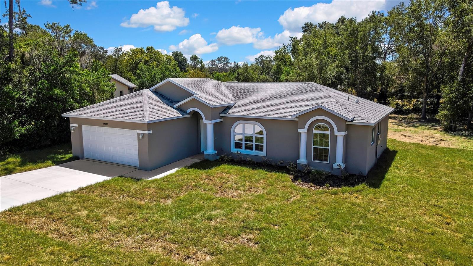 Brand New, Ready now! WOW, another beautiful Contemporary home by long time established custom builder in community. Plenty of privacy, sits on a large 0.40-acre, 100 x 170 lot. County water and sewer. No HOA or CDD fees. Three Bedroom with living room, dining room, breakfast nook off kitchen and a family room that could be used as a 4th bedroom. Builder warranties. Gorgeous, open floor plan layout; vaulted ceilings; tray ceiling in Primary Bedroom. Primary suite with walk-in closet; tiled shower. Shaker style Kitchen cabinetry, Pantry. Laundry room w extra storage closet. 2 car garage with side service door. Covered large Lanai overlooking the huge yard. Close to Beach, Fishing, Boating, Shopping, Dining, and Golfing. Call today!