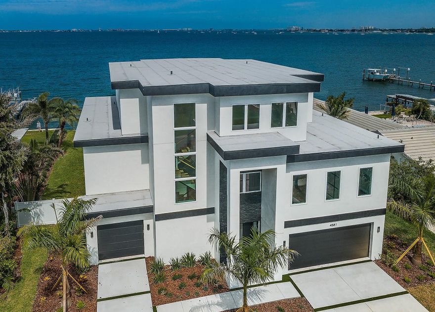 Under contract-accepting backup offers. BRAND NEW LUXURY WATERFRONT RESIDENCE BY ROSSI CONSTRUCTION!  Resting on huge open water with spectacular sweeping views of Boca Ciega Bay, discover a magnificent coastal estate that leaves nothing to be desired.  A graceful entry foyer opens to a terrific executive office and a sprawling great room with an exquisite, dedicated wetbar and commanding views of the waterfront.  Walk out to the fabulous covered waterfront balcony with outdoor cooking and entertainment center, and access to the spacious 50ft wide lower-level covered lanai.  The spacious and grand owner’s suite boasts dazzling waterviews and plenty of storage.  Pamper yourself in the glorious owner’s bath with elegant soaking tub, lavish dual vanities, superb walk-in shower and a massive walk-in closet with exceptional closet system.  The sumptuous gourmet kitchen features stunning counters and rich coastal cabinetry, high-quality appliances, extensive counter space, a center island bar and an oversized walk-in pantry.  Adjacent to the kitchen is the chic waterfront dining area, delivering an ideal formal and informal dining experience.  Upstairs you’ll find 3 large bedroom suites with walk-in closets and full luxury baths – with two of the suites overlook the waterfront and enjoying private access to a wide, covered waterfront balcony.  The massive lower level is designed to be multi-purpose and supports 8 car garage parking.  Step out to the generous lanai deck and a dazzling pool and hot tub that overlook the waterfront.  The home includes a 3-stop elevator, gorgeous wood floors, bedroom closet systems and a luxurious selection of materials, tile, woodworking and fixtures.  Situated with almost a perfect western exposure, you will relish unforgettable sunsets across more than 2 miles of extraordinary open water - with the lights of St. Pete Beach in the distance.  Enjoy a relaxed, contemporary waterfront lifestyle with easy, rapid access to downtown St. Petersburg, the beaches and Tampa International Airport.  Invite you to compare – this is arguably the best new construction waterfront value found anywhere in Tampa Bay!  Dimensions are estimates.  Buyers to confirm dimensions.