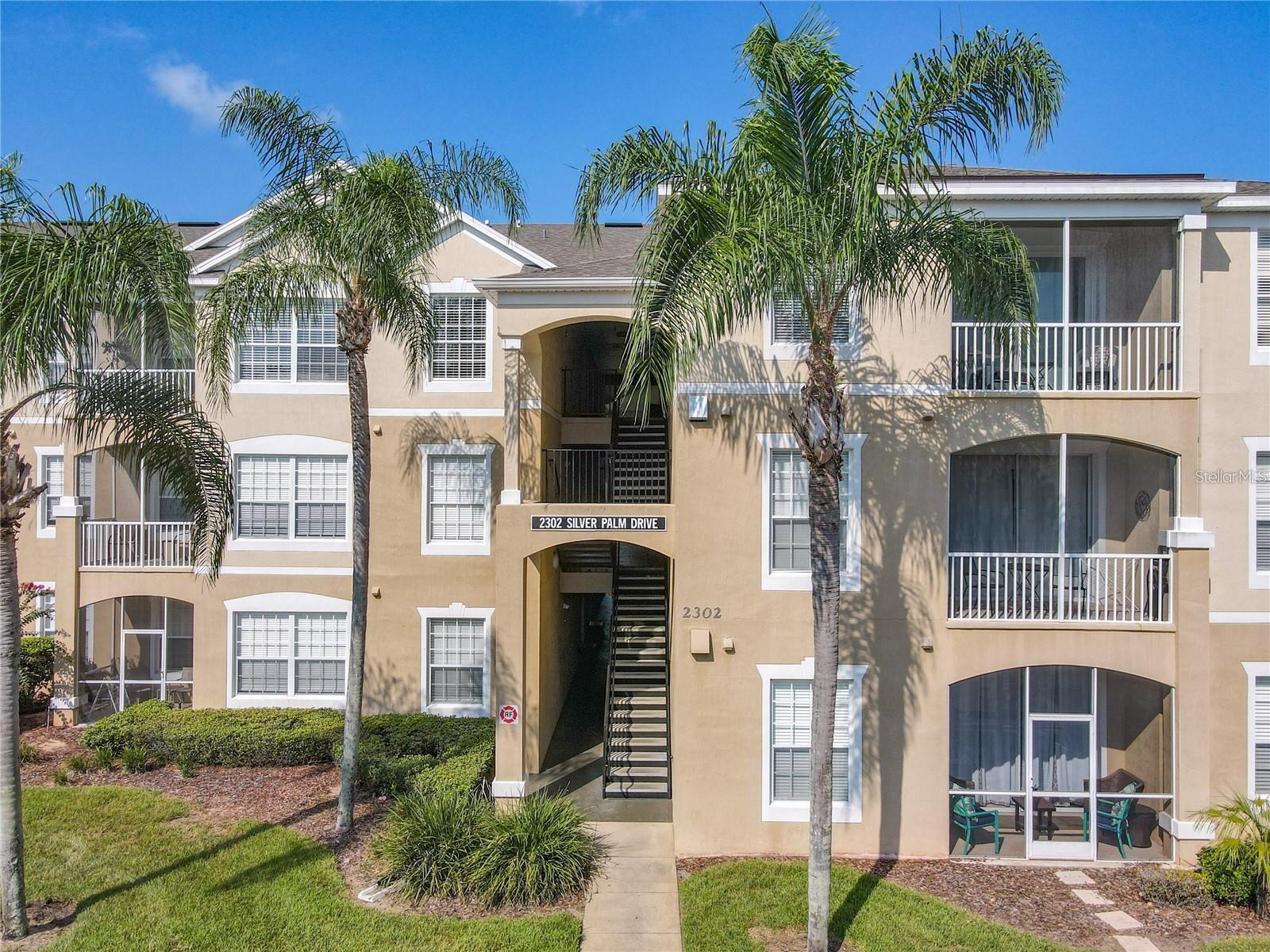 Don’t miss this rare first floor condo in the sought-after Windsor Palms Resort! Step inside and enjoy a bright, open layout featuring a combined living and dining area that flows seamlessly to a screened patio, perfect for relaxing after a day at the parks. The split bedroom design offers privacy and comfort. On one side, you’ll find a spacious primary suite with a walk-in closet and private bath. The opposite side includes a large second bedroom and a generous third bedroom, which share a full bath. All bedrooms and the main living areas feature new LVP flooring. This condo comes fully furnished and move-in ready, complete with stainless steel appliances, washer and dryer, and everything needed for a fantastic vacation rental or personal retreat. A newer AC unit provides peace of mind. Windsor Palms is a gated resort community with 24-hour security and a long list of amenities: a resort style pool, hot tub, splash pad, fitness center, clubhouse with arcade and movie theater, tennis, basketball, playground, Tiki bar, and more. Perfectly located just minutes from Disney, golf, restaurants, shopping, and entertainment, this condo is zoned for short-term, long-term, or full-time living. Opportunities for ground floor units like this are few and far between, schedule your showing today!