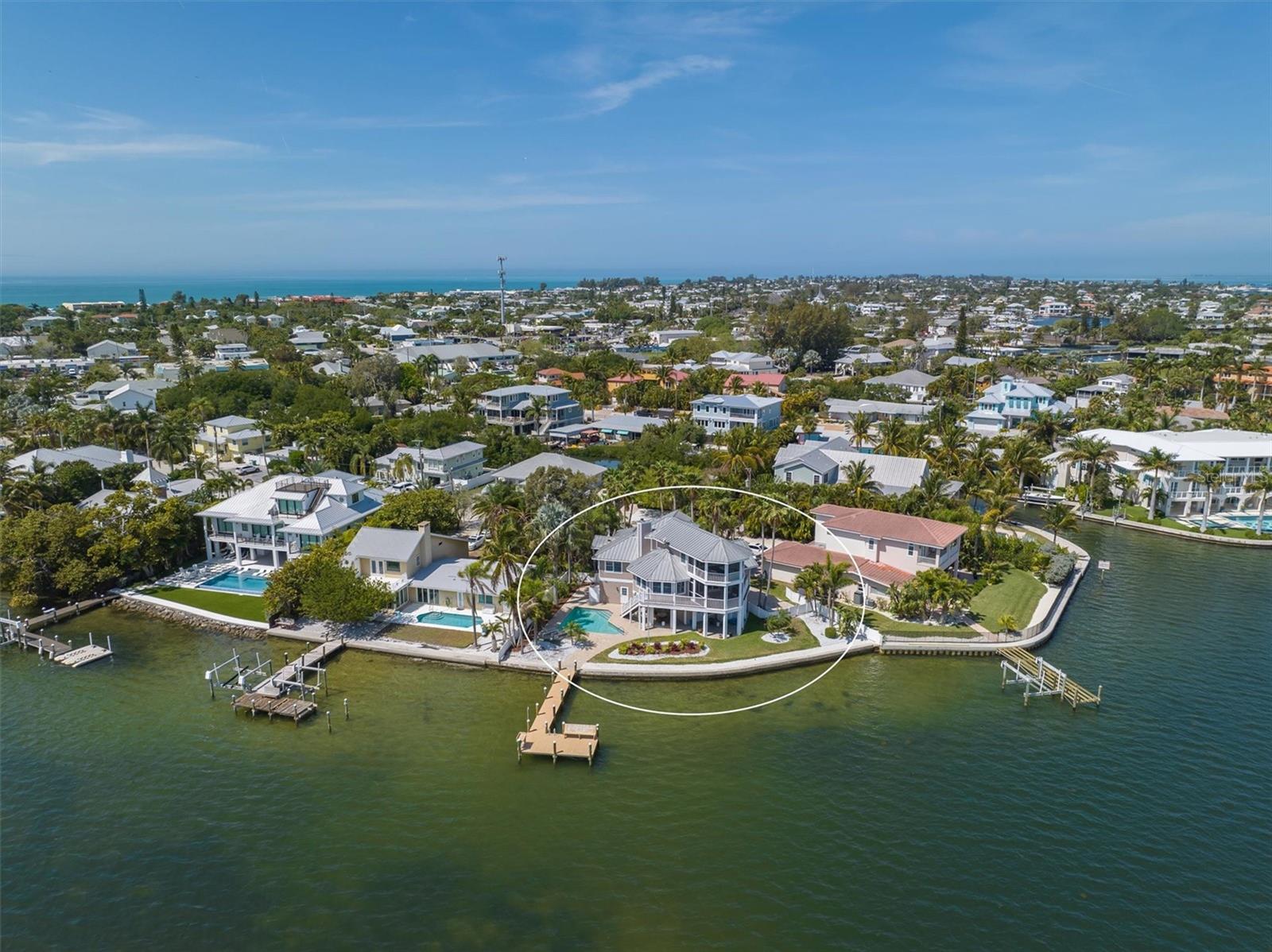 WATERFRONT home offers panoramic views of the Intracoastal Waterway and Tampa Bay!! Stunning 3 bedroom, 2.5 bathroom was recently updated with exquisite decor that seamlessly blends modern luxury with coastal charm, promising a lifestyle of comfort and relaxation. Designed by local architect Emily Ann Smith this exquisite waterfront retreat is located on a quiet cul-de-sac in the heart of Holmes Beach on Anna Maria Island. As you step inside, you are greeted by an open-concept living space bathed in natural light streaming through large windows, a wood burning fire place, framing picturesque views with boats gliding by and watching dolphins frolic in the water.
The living room opens up to a large screened patio that is perfect to relax and have your morning coffee greeted by intercostal breeze. The kitchen is a culinary enthusiast's delight, featuring a large island, wine fridge and more. Whether you're preparing a casual breakfast or hosting a gourmet dinner party, this kitchen is sure to inspire your inner chef. On the main level, there are two bedrooms with a shared bathroom with a walk in shower, and a half bath for guests. This floor has elevator access from the ground level foyer. The top floor is complete with a large Master ensuite with a private screened in porch with panoramic views for ultimate peace and privacy. The backyard is fenced with landscaping, heated pool and private dock. The private dock, providing direct access to the intercostal waterway for boating, fishing, and water sports enthusiasts. Whether you're an avid sailor or simply appreciate the beauty of waterfront living, this home offers the ultimate coastal lifestyle experience. More features is a covered area that is the perfect spot for an outdoor kitchen or bar area and there is a side entry garage as well as an additional garage and storage area that would be perfect to store all your beach toys and fishing poles. Located in a sought-after neighborhood, very quiet, 30 day rental minimum, this property is just minutes away from pristine Gulf beaches, local restaurants and shopping ensuring that every day feels like a vacation in paradise. Don't miss your chance to own this breathtaking waterfront haven – schedule your private showing today and start living the life you deserve.