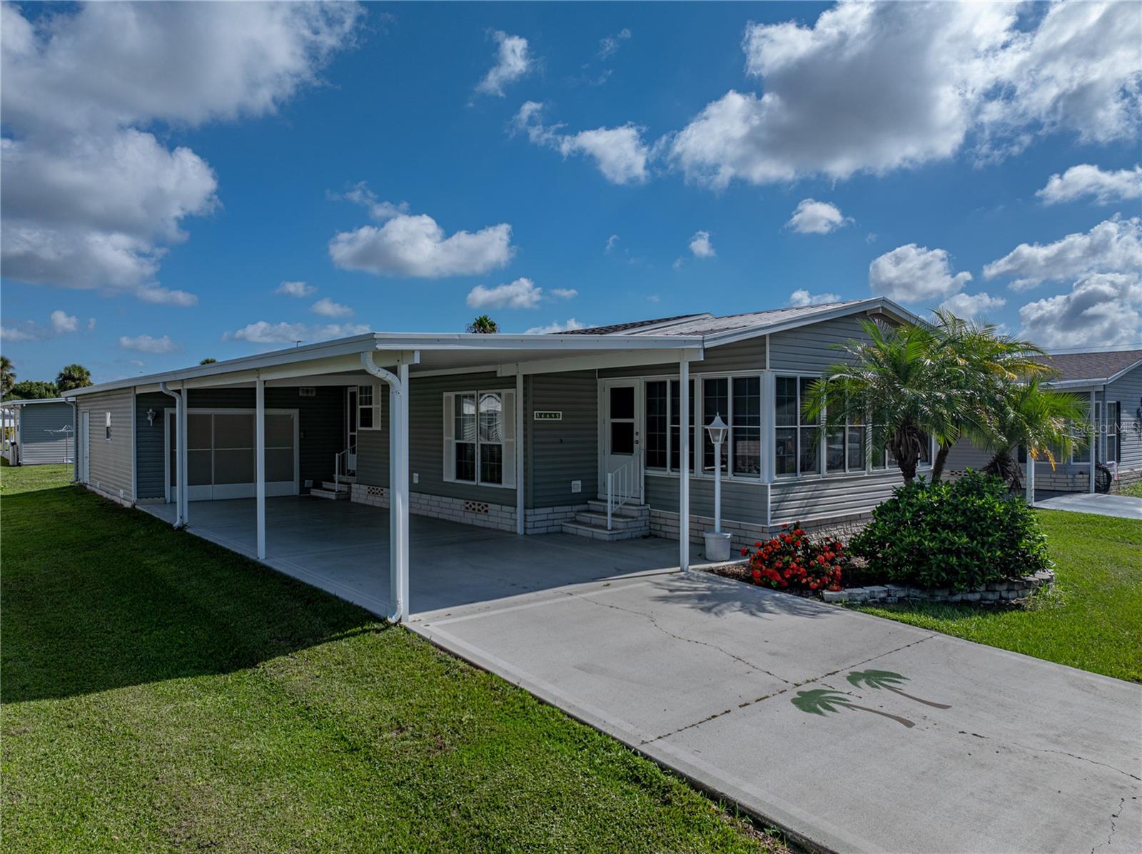 Florida Living at its finest! Enjoy living in one of the Tampa Bay Area's most sought after and active 55+ communities! With over 124 acres of common grounds, Betmar boasts 27 holes of golf, 2 swimming pools and spas, 24 covered shuffleboard courts, outdoor tennis, pickleball and bocce ball courts and 3 very active clubhouses where you may enjoy social events such as monthly dinners and breakfasts, music, games, theater and holiday events. This lucky homeowner need never be bored with over 25 active clubs and numerous monthly calendar events. For the adventurous spirit, Betmar offers travel from local day trips to international group travel options. At Betmar, YOU get to decide how to live YOUR best life. You may prefer to simply relax and enjoy the peaceful surroundings of the many lush gardens, fountains, and ponds, or a relaxing game of miniature golf next to the gazebo and covered bridge or a stroll through Memorial Lane may be more your style. In that regard, you will be pleased to know membership for the golf and aquatic clubs is completely optional. In addition, there are NO lot fees here. When you purchase this home in Betmar, you own your land. This spacious, open concept, one-owner home is located in the coveted “pet area” of the community and the neighborhood dog park is a shaded paradise for the four-legged residents. This home shows like a model and boasts many construction upgrades including, double pane windows with marble sills, sheetrock interior walls with rounded corners, brushed nickel lever door handles, french doors leading to a cozy flex space/den and 2-inch blinds and custom window coverings throughout. New LVP waterproof flooring was installed in 2021. Kitchen cabinets were updated with pull-out shelving, and a contemporary LG 3-door craft-ice refrigerator was purchased in 2022 along with the Samsung washer and dryer matching set. The full-length sunroom at the front of the home, along with 4 solar tubes allow for a light and airy interior design, which extends throughout the kitchen, laundry, and bath. Outside, you will find an oversized shady carport leading to the 2-car tandem garage with electrical wiring and a full-length retractable garage door screen, along with a separate entrance for golf cart, perfect for a workshop, man cave or outdoor craft area.