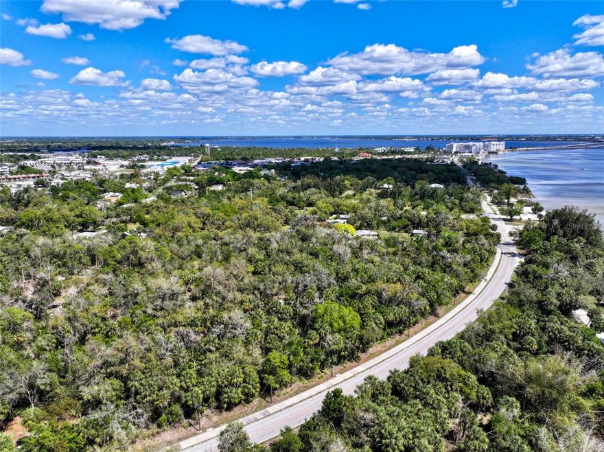 Charlotte Harbor Gateway off Bayshore road presents a rare opportunity to own 8.3 ± acres along the highly desirable Charlotte Harbor corridor. This property features extensive frontage on Bayshore with utilities at the road and offers flexible zoning suitable for a variety of residential and investment uses.  The north 5.95 ± acres is zoned Charlotte Harbor Mixed Use (CHMU), allowing up to 15 units per acre, while the southwest 2.35 ± acres is zoned Charlotte Harbor Neighborhood Business Residential (CHNBR), permitting up to 10 units per acre with limited neighborhood scale commercial uses. The property currently allows an estimated 114 units, with potential for increased density under the Live Local Act, including building heights up to 90 feet.  Ideally located just ½ mile from Sunseeker Resort Charlotte Harbor and US 41, the property may offer potential views of Charlotte Harbor and is positioned in a rapidly growing area of Port Charlotte. The proximity to the harbor provides both scenic value and long-term desirability.  This tract is well suited for a private estate, long term land hold, or future residential development, with flexibility to accommodate a range of uses including multi-family, townhomes, or a thoughtfully designed mixed-use concept.  This property is vacant land to be subdivided from a larger parent parcel, with the subject property located entirely on the north side of Bayshore Road.  Acreage is approximate and subject to final survey. A new parcel ID will be assigned prior to or at closing, and the final legal description will be determined upon completion of the subdivision.  Taxes are estimated based on a pro-rata share of the parent parcel and will be finalized after subdivision.  Buyer to verify all information, including acreage, zoning, and tax allocation.
