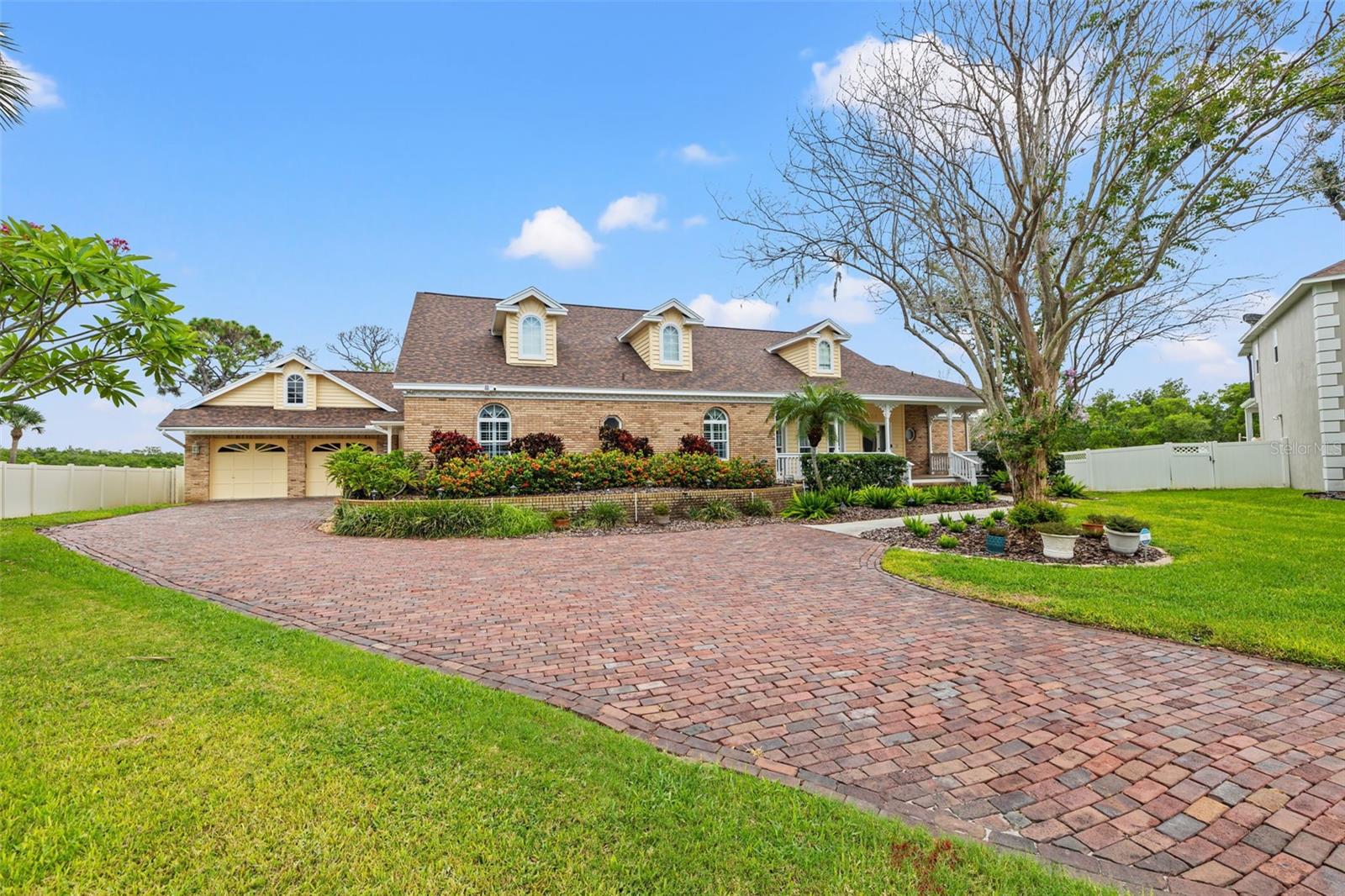 WATERFRONT LUXURY WITH GULF ACCESS — A CUSTOM-BUILT RETREAT LIKE NO OTHER.Set on over half an acre at the end of a brick-lined cul-de-sac, this 5-BEDROOM, 4.5-BATH, 3-CAR GARAGE John Daniels home offers panoramic views of Cross Bayou, a signature shell-shaped pool, and a private dock with lift for paddle boards, kayaks, and canoes. Inside, over 4,600 square feet of thoughtfully designed living space blends custom details, multiple gathering areas, and indoor-outdoor living at its finest.
A wide front porch and stained-glass-accented entry welcome you into formal living and dining rooms with crown molding, plantation shutters, and views of the pool and fenced backyard. The heart of the home is the spacious kitchen with custom cabinetry, large center island, dual ovens, under-counter ice maker, and brick cooktop surround. Coastal-themed quartzite countertops extend into the kitchen, wet bar, and primary bath, tying together the home’s bright, timeless aesthetic.
The main-floor primary suite offers private porch access, a custom walk-in closet, and five-piece bath. Two additional bedrooms on the main level share a Jack-and-Jill bath connected by a versatile hallway ideal for an office nook or reading space. A conveniently located guest bath serves the main living areas. The large laundry/mud room with extra storage and secondary refrigerator connects to the oversized detached three-car garage, which includes a loft, workshop area, and pool bath.
The inviting family room features vaulted cedar ceilings, a brick fireplace, and sliding doors opening to the covered porch and expansive yard. Upstairs, a large bonus/game room offers endless possibilities—media, fitness, play, or studio space—flanked by two bedrooms, a guest bath, and French doors leading to the wraparound balcony with sweeping water views.
Outdoor living is the highlight: a custom shell-shaped pool and spillover spa, fully fenced yard, gas-ready gazebo, and composite dock with 13x13 platform lift for launching water toys directly into secluded waterways with Gulf access.
Additional features include: three-zone A/C, water softener, freshly painted exterior, new pool equipment, vaulted and beamed ceilings, and pass-through to pool deck. Located within Seminole Lake Golf & Country Club, residents enjoy optional golf, tennis, and social memberships, making this an exceptional opportunity in one of Seminole’s most unique waterfront enclaves.