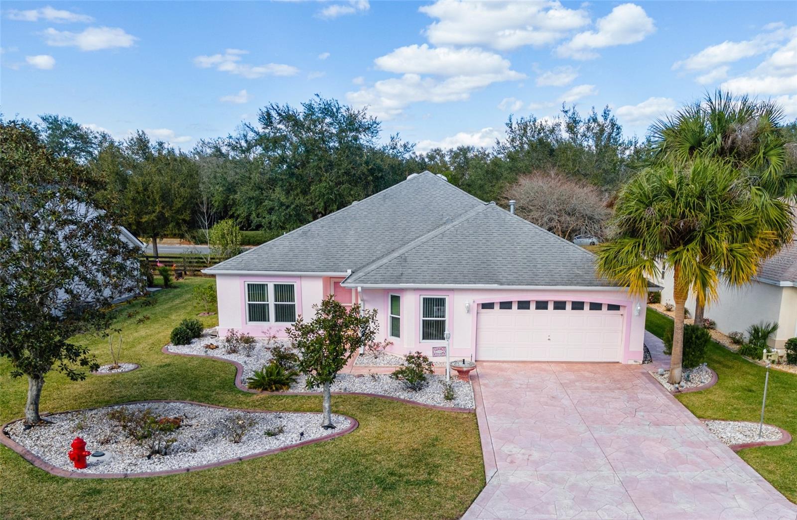 Under contract-accepting backup offers.One or more photo(s) has been virtually staged. WOW, this home has a ONE-OF-A-KIND design with Florida outdoor living in mind! You MUST SEE this unique, E-X-P-A-N-D-E-D JASMINE (formerly SARATOGA III) Designer home located in the VILLAGE of SANTO DOMINGO! It features a 3 BR /2 BA /2 Car Garage w/ BOND PAID, NO HOMES BEHIND, & innovative changes to the footprint of the home completed in a huge rear addition (2011). This home could serve as a blank slate for whatever you desire! Imagine the possibilities for YOUR next retirement home complete w/ the unmatched VILLAGES LIFESTYLE! Located on a quiet, CUL-DE-SAC street, this home has MATURE LANDSCAPING w/ CONCRETE CURBING & ROCK FILLED beds, and color coordinated IMPRINTED CONCRETE walkways & driveway. A GLASS STORM DOOR protects the front door from the weather elements. Once inside the FOYER, you will immediately notice the FRESH INTERIOR PAINT (3/2023) and unique CORK FLOORING which flows through the kitchen, formal Dining Room, and hallways. The KITCHEN is located to the R of the Foyer and has a pass through window to the DINING ROOM. There are abundant OAK CABINETS with lower cabinet PULLOUTS and a built-in pantry. CREMA BORDEAUX GRANITE adorns the countertops. White appliances include a new dishwasher (2023) and a GAS STOVE (2011). The breakfast nook has plenty of NATURAL LIGHT through NEWER, DOUBLE PANE WINDOWS (2017) because of the SOUTHERN front exposure. The garage can be accessed from the kitchen so bringing in the groceries will be a much easier task! Back to the main LA, the VAULTED CEILINGS give a spacious feel to the combo LR/DR area and a SOLAR TUBE provides natural light. A set of SLIDING GLASS DOORS leads to both ENCLOSED LANAIS. This home features a popular SPLIT BEDROOM FLOOR PLAN w/ the guest wing to the L of the Foyer. Located between two sizeable bedrooms (BR #3 & BR #2), Bathroom #2 has a TUB/SHOWER combo, single vanity w/ matching granite countertop, and a NEW COMFORT HEIGHT TOILET. BR #2 is the rear bedroom and has SLIDING GLASS DOORS leading to the PLEXIGLASS ENCLOSED, LANAI #1. Moving to the opposite side of the home, the INSIDE LAUNDRY room contains a washer (2004), gas dryer (2004), a solar tube and plenty of cabinet storage. The Master BR has a large walk-in closet w/ CUSTOM CLOSET ORGANIZATION and a space saving POCKET DOOR. The ENSUITE bathroom has dual sinks/vanity, matching GRANITE COUNTERTOPS, COMFORT HEIGHT TOILET, and WALK-IN SHOWER. Now for the most exciting part of this home…a 38’ x 13’ SCREEN ENCLOSED, LANAI #2 w/ a matching IMPRINTED CONCRETE floor, impressive TRAY CEILING, a HOT TUB, a huge STONE FIREPLACE w/ plumbed natural gas, and a SUMMER KITCHEN w/ JENN-AIR grill, granite countertops, sink, and refrigerator! Other notable perks include: New electric panel (5/2023), built in and freestanding BOSE SPEAKER SYSTEMS, RING video doorbell, ARCHITECTURAL SHINGLE ROOF (2011), HVAC (2006), WHOLE HOUSE WATER SOFTENER system, 3 sets of ATTIC PULL DOWN STAIRS w/ storage space (garage & enclosed lanais #1 & #2), two citrus fruit trees, and a matching IMPRINTED CONCRETE WALKWAY to the rear of the home on the east side where you will find extra storage space. Where can you find a home with all of these features, a super convenient location close to the US Hwy 441/27 commercial corridor for your everyday conveniences, rec centers & golf courses nearby, and FREE NIGHTLY ENTERTAINMENT at either Spanish Springs or Lake Sumter Landing town square? Make an appointment today - CALL NOW!