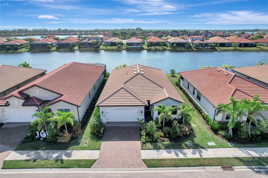 Live in the resort-style community of Toscana Isles, where every day feels like a getaway. This newly (2024) built 4-bedroom, 2-bath Delray model offers 2,023 sq ft of thoughtfully designed space with over $60,000 in premium upgrades, a stunning water view, and a prime location near the best of Florida’s Gulf Coast.
You’ll love the high 9-foot ceilings, 8-foot doors, crown molding, and wood-look tile flooring throughout—no carpet in sight. The home also features all hurricane impact windows and doors for enhanced safety and peace of mind. The open-concept layout flows seamlessly from the spacious great room to a gourmet kitchen featuring upgraded quartz countertops, soft-close cabinetry with 42” upper cabinets, stainless steel appliances, under-cabinet lighting, and a walk-in pantry. Step outside to a screened lanai with a fully equipped outdoor kitchen—perfect for enjoying your morning coffee or evening meals lakeside.
The primary suite is a private retreat with two well-sized walk-in closets and a spa-like bath that includes dual quartz vanities, a frameless glass shower, and a stylish corner bench. Additional highlights include epoxy-finished garage floors, custom cabinetry in the laundry room, and a modern smart home system for security and remote control directly from your smartphone.
Toscana Isles offers exceptional amenities: an 8,000 sq ft clubhouse overlooking a 60-acre lake, a heated infinity-edge pool, fitness center, tennis and pickleball courts, kayak launch, dog park, and scenic walking trails. Located just 2 miles from the new Sarasota Memorial Hospital – Venice campus, 6 miles from Nokomis Beach, and only 7 miles to Historic Downtown Venice with its charming boutiques, dining, and culture.
With convenient access to I-75, daily commutes and weekend getaways are a breeze. Enjoy being just a short 25-minute drive from the world-renowned Siesta Key Beach and the cultural attractions, dining, and shopping of vibrant Sarasota.
This home is located in X flood zone, so no flood insurance is required. Impeccably maintained, filled with elegant details, and move-in ready—this is the Florida lifestyle you’ve been waiting for.
