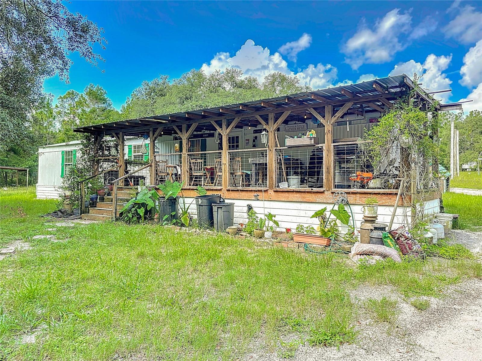 One or more photo(s) has been virtually staged. Bring all your toys and enjoy the space! This 2-bedroom, 2-bath split-floorplan mobile home sits on 5.3 acres in peaceful Keystone Heights, with an enormous front porch overlooking mature oaks. Featuring a large detached garage perfect for RVs, four-wheelers, dirt bikes, tools, and more. The home has a newer roof, updated plumbing and electric, new windows, and a spacious kitchen with an island. There's plenty of room for a garden, fruit trees, or even a future pool. With a little TLC inside, this home could be your perfect country retreat. No HOA—just land, space, and freedom! Schedule your private showing today before it's gone!!