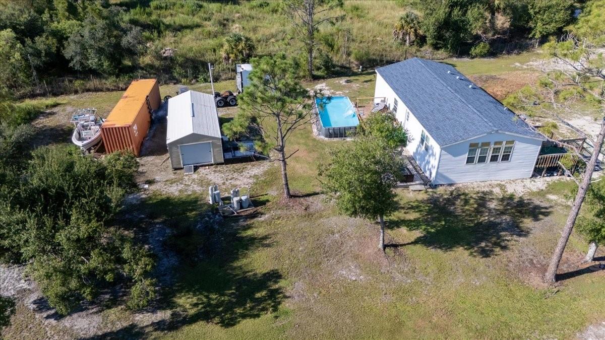 Looking for the perfect country lifestyle? Look no further! This beautifully maintained 2-bedroom, 2-bath, PLUS bonus room home on 1.25 acres offers peaceful country living with the freedom of agricultural zoning, no HOA, and no flood zone—offering privacy, flexibility, and endless possibilities. Step inside to an open-concept floor plan filled with natural light. The kitchen is a standout with abundant cabinetry, generous counters, and an exquisite oversized solid quartz breakfast bar—perfect for family meals or entertaining. The living areas flow seamlessly, highlighted by durable NuCore flooring that combines style and easy care. The spacious primary suite offers a walk-in closet with his and her doors and a luxurious ensuite with dual sinks, abundant cabinetry, and a large walk-in shower. The guest bath includes a shower/tub combo for added convenience. Additional upgrades include crown molding, new baseboards, modern retractable fan/lights with color-changing options, and an inside laundry room. Outside, enjoy true country living with a 420 sq. ft. insulated, drywalled and painted shed/workshop, sparkling pool with deck area—ideal for relaxing or entertaining, new roof (2022) and new siding with OSB board (2024). Convenient back door to pool area. This home combines rural charm with modern upgrades—perfect for a private homestead or simply extra room to roam. And with its prime location near shopping, dining, Punta Gorda Airport, beaches, fishing, and boating, you’ll never be far from everything you need. Schedule your private showing today!