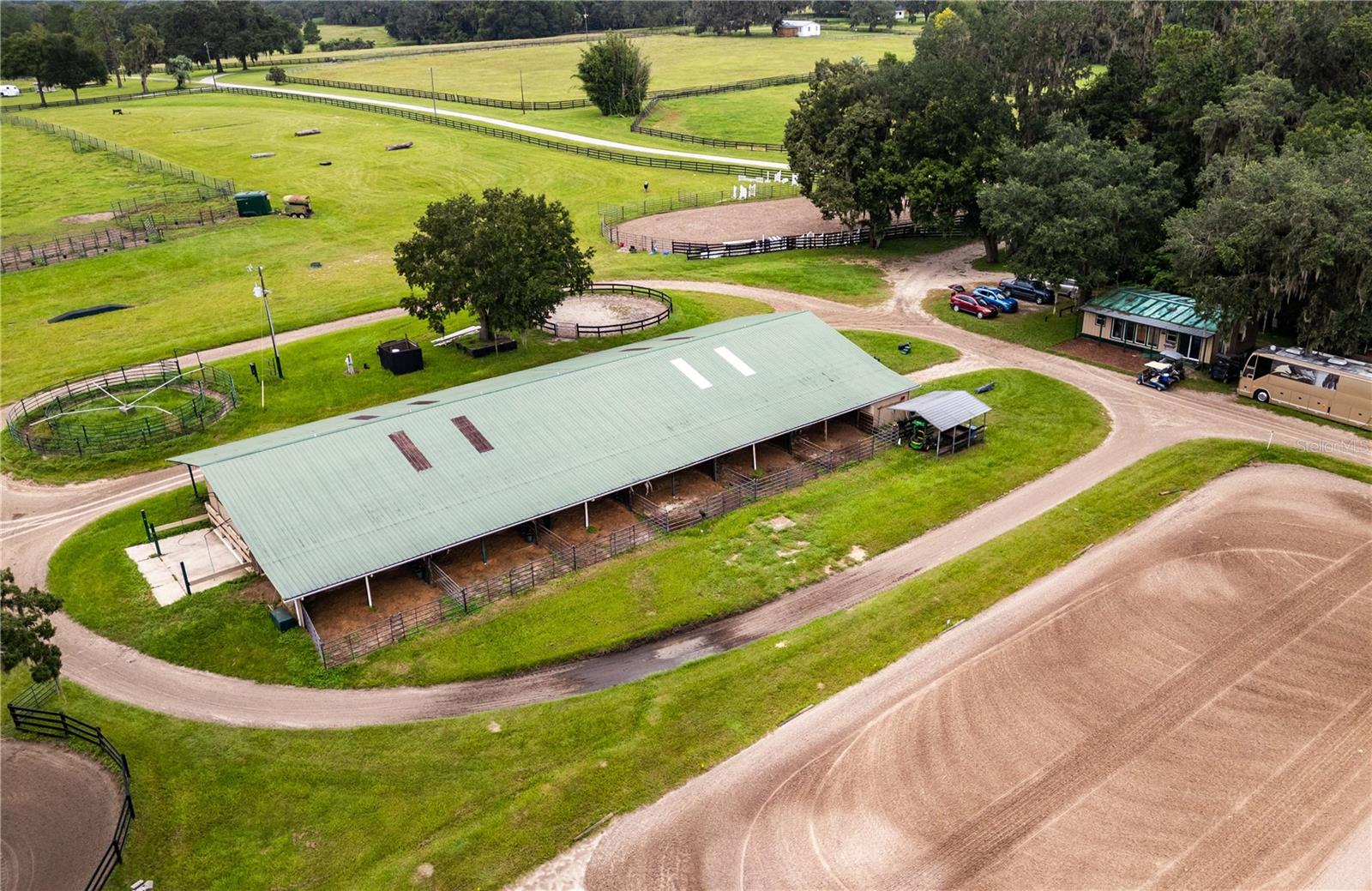 Situated in Marion County’s renowned NW region amongst established horse farms, this incredible farm combines two lots for a total of 70.74 acres of equestrian opportunity. Close to both HITS and the World Equestrian Center, this farm has ample potential for horsemen of multiple disciplines with the right vision. In an area known for its high-quality soil and lush grass, this property is no exception– limestone enriched soils create an ideal environment for raising happy, healthy horses here in Marion County’s horse country. The farm’s main center-aisle barn is thoughtfully equipped with a total of 14-stalls and a variety of features including a tack room, feed room, and wash rack. This barn also includes a barn apartment and additional barn office, making it easy to separate personal and business or to offer potential seasonal rental space for passive income. Separate from the main barn is a hay barn which provides plenty of storage space. A total of 11 paddocks of varying sizes are currently in place, offering a good variety depending on your needs. Large, open pastures are also established and could easily be further divided into smaller paddocks or other equestrian facilities as desired. An additional round pen, and multiple arenas are also in place, providing plenty of options for those looking to keep up their training all year long. The property’s 4-bedroom, 3-bath home provides plenty of space with over 2,800 SqFt under air. The split-bedroom floor plan provides plenty of privacy and a great starting point for those who would like to make this home their own with some thoughtful updates. This farm is an exceptional option for equestrians looking to get the most out of the Horse Capital of the World®, with ample opportunity to further customize the property to suit your needs!