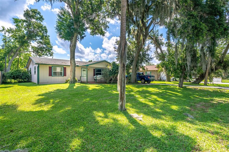 2 bedroom, 2 bath, single car garage nestled under large oak trees in the heart of Florida Shores. This home features an open floor plan, large wood-burning STONE fireplace. Carpet throughout living room and bedrooms. Guest bathroom has tile flooring, single vanity and tub/shower. Vinyl flooring through kitchen/dining area (kitchen could use a little updating.) Walk out of kitchen into enclosed Florida room. This home also features a large fully FENCED back yard, fully equipped for your fur baby. NEW roof and NEW central A/C within past 5 years. CASH or CONVENTIONAL offers only. ;Water: City