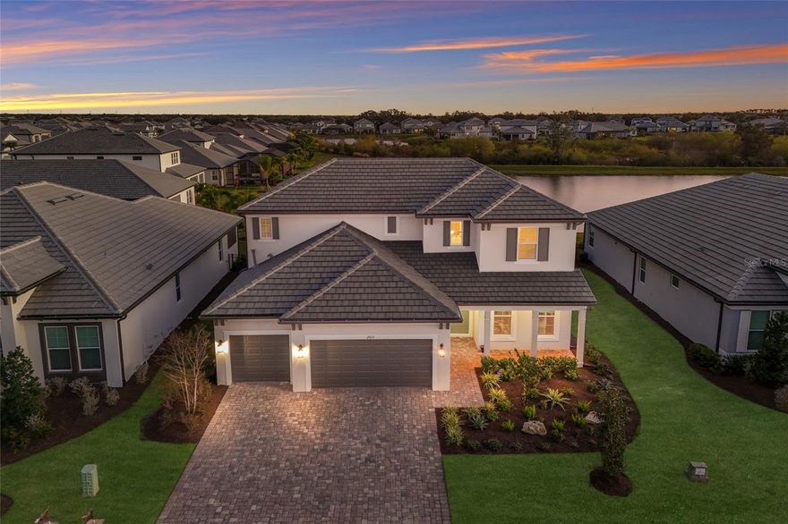 This modern pool home situated in the highly desirable Sweetwater neighborhood in award-winning Lakewood Ranch exudes luxury & elegance every step of the way! Meticulously maintained and nearly new, this stunning 4-bedroom, 3.5-bath Juniper floorplan by M/I Homes is loaded with upgrades and perfectly positioned on a lushly landscaped lot with southern-facing pond views and peaceful conservation in the distance. The curb appeal is undeniable, with its British West Indies inspired elevation, modern ceramic flat tile roof, pavered driveway, & inviting front porch. Step inside to a dramatic, soaring foyer open to the second floor, accented by custom wood wall trim for an elegant, finished look. A versatile den just off the foyer offers the perfect flex space, ideal for a home office, media room, or playroom. Beyond the foyer is your open concept gourmet kitchen, formal dining room, Great Room, and Kitchen Cafe. The large designer kitchen showcases staggered 42" cabinets, stainless vent hood, quartz countertops, natural gas cooktop, double wall oven, tile backsplash, & oversized walk-in pantry. The Cafe easily accommodates everyday dining, while the formal dining room is ideal for upscale gatherings, enhanced by a custom dry bar with built-in wine fridge and wine racks. Your Great Room dazzles with its tray ceiling, sparkling chandelier, and stunning custom marble and stacked-stone fireplace wall. Impact sliders from the Great Room lead you to the crown jewel of the home...your GORGEOUS, extended, screened-in lanai and heated saltwater pool with cascading waterfall feature & water bowls. The custom outdoor kitchen is an entertainer's dream & includes fridge, wine fridge, gas grill, & 2 burners. Enjoy serene, southern-facing pond views, a backdrop of tropical landscaping, & privacy hedging that transforms this space into a true backyard retreat. Imagine relaxing under the pergola with your favorite beverage in hand while you watch the sunset in the distance! Back inside, the impressive oversized Primary Retreat delights with its tray ceiling & crystal chandelier. Your Primary Bath includes extended vanity w/quartz counters, double sinks, custom vanity lighting, walk-in shower w/floor to ceiling tile, soaking garden tub, & HUGE walk-in closet. Venture upstairs and you'll find the spacious loft/game room, two additional bedrooms with a shared hall bath, and a fourth bedroom that serves as a private Guest Suite with its own walk-in closet & full en-suite bath. One of the bedrooms is brilliantly styled as a home theatre, complete with custom accent slat wall. A stylish powder bath sits just off the foyer for guests, while a HUGE Super Laundry Room just opposite impresses with built-in upper & lower cabinetry and a generous bonus area - perfect for a home gym, pet care station, or extra storage. Other notable features include: Impact windows throughout; Custom designer lighting; Custom window treatments; In-ceiling speakers; Security system on windows & doors; Epoxy floors in garage; Tankless gas water heater & more! Residents of the gated Sweetwater community enjoy access to a world-class amenity center featuring a resort-style pool, fitness center, pickleball & sports courts, a vibrant clubhouse/social hall, & more. Primely situated in Lakewood Ranch, the #1 multigenerational community in the U.S., with top-rated schools, shopping, dining & entertainment nearby, easy access to I-75, & less than 40 minutes to Siesta Key Beach & Anna Maria Island.
