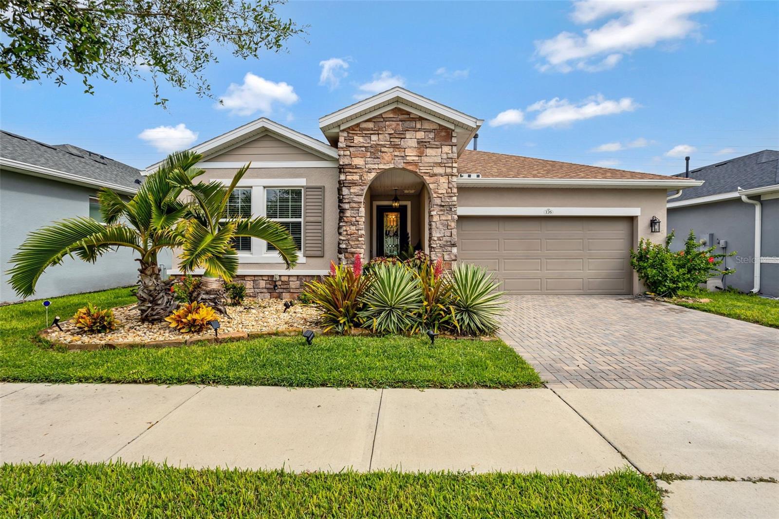 Welcome to your dream home in one of the area's most desirable 55+ guard-gated communities known as Cascades of Groveland or Trilogy! This beautifully maintained 2-bedroom, 2 and a half bathroom plus den residence is loaded with premium features and thoughtful upgrades for effortless, elegant living. Step inside to discover rich hardwood floors throughout the main living areas, an open-concept layout, and a custom-built bar area perfect for entertaining. The stylish kitchen is a chef’s delight with a gas range, ample counter space, and high-end finishes. The versatile den offers space for a home office, guest room, or creative studio. Enjoy Florida living year-round on the expansive 40x28 covered and screened lanai, complete with hurricane-grade automatic shades and ceiling fans—ideal for relaxing or entertaining in comfort and style. The home sits adjacent to the community pond which offers beautiful views and the benefit of added privacy. This energy-efficient home also features solar power, helping reduce utility costs while supporting sustainable living. Additional highlights include built-in closets, a laundry room with custom cabinetry, and custom garage storage. Located in a vibrant 55+ active lifestyle community, residents enjoy access to a clubhouse with an on-site restaurant, heated pool, gym, tennis & pickleball courts, walking trails, activity rooms, and a concert/event center that hosts year-round social events. This move-in ready home combines luxury, function, and community in one perfect package. Schedule your private showing today!