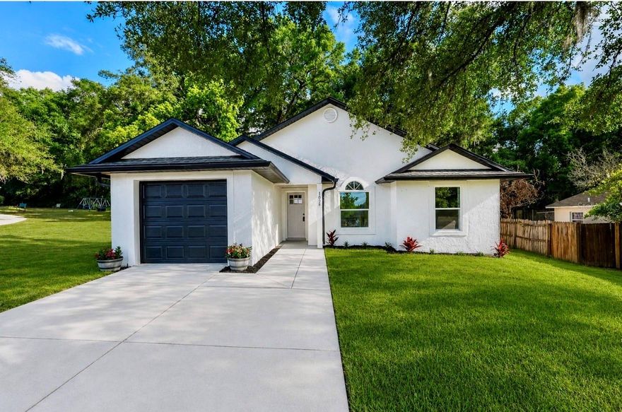 Fully renovated and move-in ready — 1038 Sheeler Hills Dr is a turn-key 4-bedroom, 2-bath home in the heart of Apopka, just north of Orlando. Every system, surface, and finish has been redone, so there's nothing left for a buyer to do but unpack. Step inside to a bright, open-concept great room with vaulted ceilings, oversized windows, and brand-new light-wood plank flooring that flows seamlessly through living, dining, and kitchen spaces.
The designer kitchen is the heart of the home — tall light-wood shaker cabinets with crown molding, polished quartz countertops, a hexagonal marble-look mosaic backsplash, and a full stainless steel appliance package (side-by-side refrigerator, electric range, microwave hood, dishwasher) anchored by a deep single-basin sink with matte-black gooseneck faucet. A sun-filled dining area opens directly to the backyard through new sliding glass doors. Both bathrooms have been taken to the studs and rebuilt: floating wood vanities with quartz tops, oversized framed mirrors with linear LED vanity bars, modern faucets and fixtures, and a spa-style walk-in shower wrapped in large-format porcelain tile with a built-in niche.
Bedrooms are generous, light, and finished to the same high standard — vaulted ceilings, new windows, fresh paint, and the same plank flooring (no carpet anywhere in the home). The exterior was not skipped: new windows throughout, new sod, fresh paint, and a new garage door with new opener motor. Located in a quiet, established Apopka neighborhood with quick access to SR-414, SR-429, and downtown Orlando — and minutes from Wekiva Springs State Park, Kelly Park, and the West Orange Trail. Pull together the renovation, the layout, and the location, and this is one of the cleanest move-in-ready offerings in 32703.