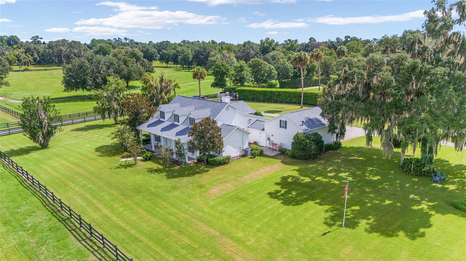 This elegant estate sits on just around 8 acres of bliss, nestled amidst other thriving farms! Located off 475 minutes to Florida Horse Park, Nearby Riding Trails and Minutes to Downtown Ocala for restaurants, medical and shopping options and the world-renowned World Equestrian Center can be reached in less than 20 minutes! The cape cod style home is an immediate eye-catcher and fully customized. Welcoming you in, the main home offers a total of 5-bedrooms and 3-baths with 3423 living sq.ft. of space. The interiors showcase abundant natural light, soaring cathedral ceilings, and stunning views of the outdoors throughout the home. A recently updated kitchen with quartz counters, new appliances, Roof 2023. Home features a gas fireplace in the living room, formal dining area, a separate sitting room to use as a flex space how you see fit, eat in kitchen - amazing porches to enjoy the views throughout. Outdoors is completely fenced with a 2-stall barn, tack room, feed area, storage, and/or workshop. Each corner of this exquisite abode is designed to provide comfort, style, and a tranquil escape from the outside world. Experience the ultimate blend of serenity, luxury, and natural beauty. Make this exceptional property your own and live a life of tranquility and indulgence. This home must close along with 7141 S Magnolia (sister property) next door. (Full listing at OM683327) But can accomodate separate purchasers.