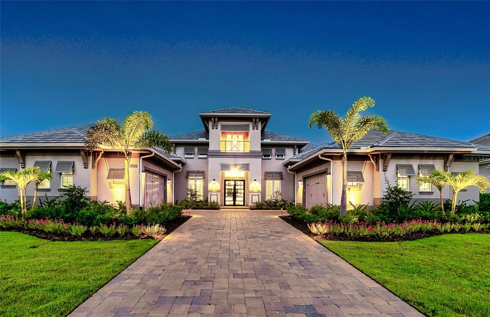 4 Bed, 4.5 Bath, Bonus Room, Office, 4,369 Sq Ft, Water Views, Heated Saltwater Pool & Spa, Expansive Lanai, Outdoor Kitchen, Engineered Hardwood, Tray Ceilings, Custom Lighting, Whole-Home Generator, Impact Doors and Windows, Resort Style Amenities. Make your home the vision of sophistication in Lakewood Ranch's most exclusive village, The Lake Club. This recently crafted Clairborne II custom model by Stock Development is a luxurious 4-bedroom, 4 1/2-bath estate spanning 4,369 square feet. The stunning home features a private study, exercise room, expansive great room, dining room, and a grand outdoor living area, complete with a four-car garage.
The heart of this residence is an expansive great room, which is beautifully illuminated with natural light and features a custom LED backlit, drop-down tray ceiling. This space seamlessly flows into the kitchen and dining areas, creating a cohesive living environment. The open kitchen has a large central island, which becomes a natural gathering spot for guests, and includes a gourmet setup with a dry bar, additional storage, and a wine refrigerator. The room's grand openness harmonizes with the cozy intimacy of its functional spaces, offering both a spacious and inviting atmosphere.
Engineered hardwood floors add elegance and durability by flowing seamlessly throughout the home. The wall of sliding glass doors in the great room not only lets in abundant natural light, but also seamlessly transitions into an exquisite outdoor space, featuring an expansive east-facing lanai. Here, you can enjoy a cozy fireplace, gourmet outdoor kitchen, and a sparkling salt-water pool and spa, all set against a breathtaking waterfront vista. The panoramic screen enclosure frames impressive water views from every corner.
The master suite includes separate his and her closets, a cozy seating area, and a lavish bath featuring a freestanding soaking tub, spacious walk-in shower with frameless glass enclosure, dual-sink vanity, and porcelain tile flooring.
Guests and family alike will appreciate the inviting accommodations in this home, featuring two comfortable bedrooms with ensuite bathrooms, a bonus room (currently used as the third bedroom), and an exercise room. Throughout the home, impact-resistant windows and sliding doors enhance security and durability, showcasing recent construction for lasting quality. For ultimate peace of mind, a whole-home generator ensures that you'll never be without power. The Lake Club offers premier amenities and recreational facilities within the community, convenient access to world-class beaches, and A-rated schools. Enjoy a Grande Clubhouse with a restaurant, pool, basketball, tennis and pickleball courts, playground, fitness center, dog park, kayaking, and fishing. This home truly offers the perfect blend of luxury, comfort, and convenience.