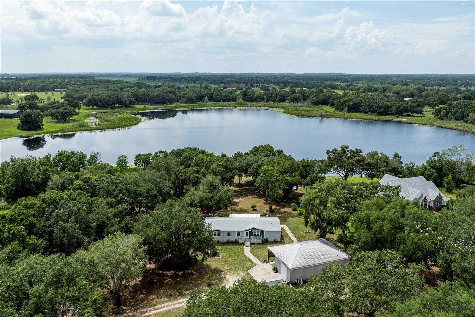 Check out the Virtual Tour! What a Beauty…This waterfront property sits along the shores of Lake Frances in Umatilla, Florida. This home offers a fantastic opportunity for a new family with its agricultural zoning and approximately 7+ acres of waterfront land with so much to offer! The home, built in 2015, features a comfortable 2022 square foot layout with a spacious split floor plan. It includes three bedrooms, two bathrooms, a living room, and a great room perfect for gatherings. The eat-in kitchen boasts ample storage and counter space, a convenient pantry, and a lovely view of the lake from the kitchen sink. There's also both an island for casual dining and a separate dining area for more formal meals. The primary suite is a true retreat, featuring an attached office or nursery, a large walk-in closet, and an en suite bathroom with a stand-up shower, dual sinks, and plenty of storage. The two additional bedrooms are both generously sized with built-in closets and are conveniently located near the guest bathroom. Outside, you'll find a screened-in back porch overlooking the serene lake. The property also includes a substantial 1200 square foot barn with a one-bedroom, one-bathroom suite and a carport. As an added convenience, the home has a freight elevator for easily moving heavier items or possibly use as a wheelchair lift. With over 200 feet of shoreline on Lake Frances, this remarkable home and its beautiful surroundings are sure to capture your interest and make you want to call it your own. New Roof 12/2024. Call for a Private Tour Today. All information recorded in the MLS is intended to be accurate however, it should be independently verified by buyer and their agent.