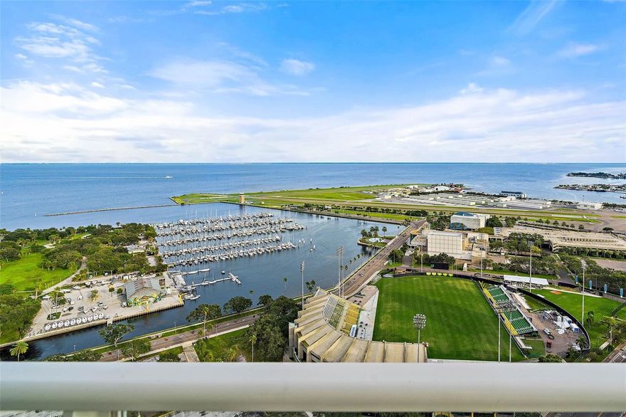 JAW DROPPING JUNIOR PENTHOUSE WITH UNOBSTRUCTED PANORAMIC WATER VIEWS! Prepare to be amazed as you step into this stylishly stunning 32nd floor, 3 bed, 3.5 bath, 2,354 SF Junior Penthouse. Nestled amongst the clouds and wrapped in walls of windows this striking residence boasts numerous features and upgrades that are sure to impress. Exquisite porcelain tile floors throughout the home are sure to catch your eye. The consummate chef’s kitchen is highlighted with superior quartzite kitchen countertops, custom designer glass tile backsplash, a center island with tailored cabinetry, and is equipped with the highest quality Wolf appliances, including a sub-zero refrigerator as well as wine fridge, microwave, dishwasher, and an induction cooktop with hood. Impressive wood doors with frosted glass inserts welcome you into every room. Each bedroom provides a spacious footprint and offers closet space with extensive custom shelving systems and all the bathrooms feature convenient dual sinks, upgraded plumbing fixtures, and specially made cabinets. Designed beyond standards, this home is also outfitted with all the latest in modern technology, including motorized blinds on all windows and balcony doors, remote control ceiling fans, and a Crestron home automation system that allows you to dim the lights, open or close the blinds, adjust your brand new A/C, operate the TV, access your internet or Wi-Fi, or control your home audio system that spreads throughout the entire residence and out onto your balcony, all from your favorite smart device. Directly off the spacious living area is your 469 SF private balcony with glass railings that run the length of the condo providing magnificent and truly special views. The Rowdies' Stadium is fully visible so you can enjoy every game without ever buying a ticket. You have a birds-eye view of the exciting downtown activities and can spend countless hours watching sailboats, yachts and jet skis cruising in and out of the marina, the planes taking off and landing at Albert Whitted Airport, and, during the annual St. Petersburg Grand Prix, you can enjoy race cars scream around the track. The unique angle placement of the building and the location of this home provides views wrapping from the east to the west, allowing you to embrace all the sights & scenes that span from the magical morning sunrises over the emerald-green waters of Tampa Bay to the renowned Skyway Bridge, and all the way over to the Gulf Beaches and evening sunsets that light the sky on fire. Included with this Junior Penthouse are two parking spaces and two climate-controlled storage units located on the fifth floor. An architectural icon with its dramatic and modern design, Signature Place is in the heart of downtown and offers resort-style amenities that include: 24/7 concierge, a grand lobby, 2 beautifully appointed club house rooms, state of the art fitness center, heated infinity edge pool and spa, outdoor grills, a putting green and more. Just a short walk to dozens of restaurants, grocery stores, retail shops and boutiques, museums, the Pinellas trail, sports arenas, and waterfront parks, living here gives you endless entertainment options.