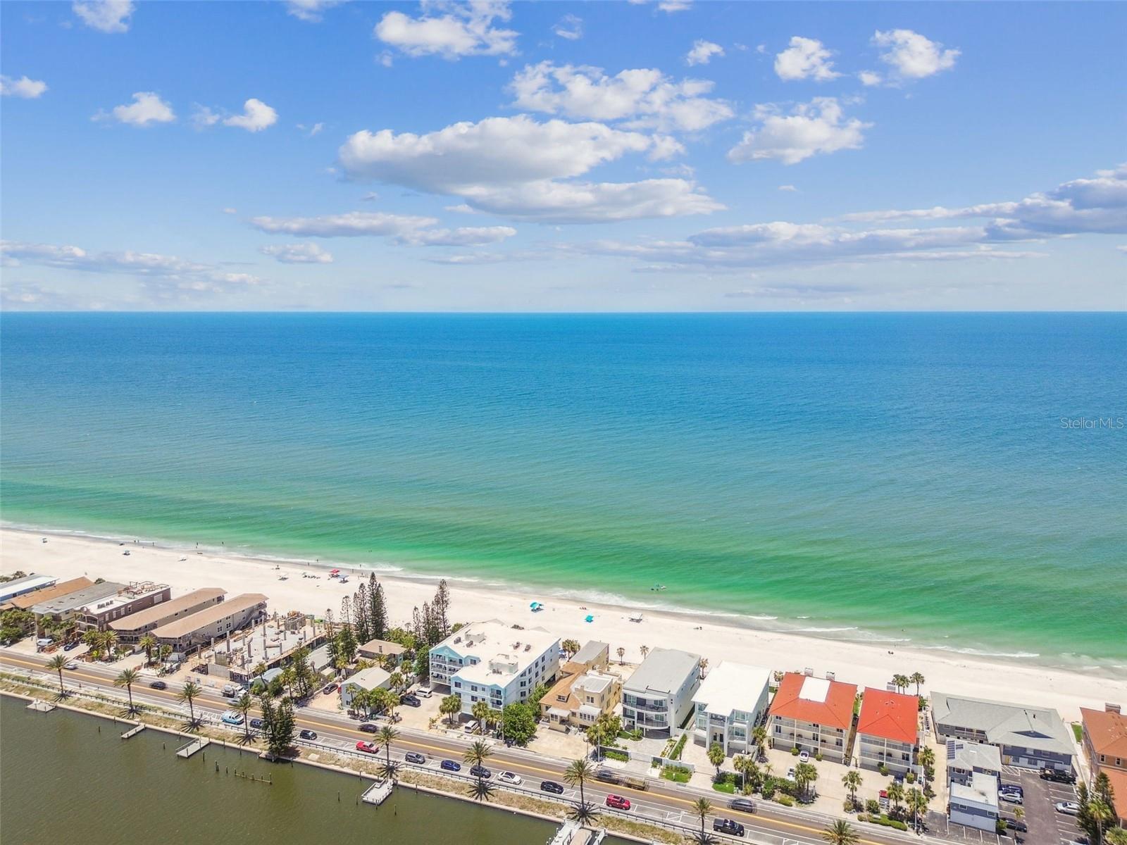 PRIME GULF OF MEXICO & INTRACOSTAL ACCESS with UNLIMITED POTENTIAL. An exceptional opportunity to own a prime beach front property on the Gulf of Mexico where the possibilities are as limitless as the views. This generously sized 15,200 sq. ft. lot (10,500 Usable) offers ample space for an exclusive custom estate or a multi-family income generating unit. Included is a dedicated space on the Intracoastal Waterway-ideal for building your own private dock and enjoying easy access to boating and water activities. The existing home, which previously housed multiple rental rooms/units is in need of a complete renovation or a teardown. It currently includes 8 bedrooms and 6.5 bathrooms. However, the true value lies in the land itself and its zoning for future development. With its strategic location on the Gulf and the Intracoastal, this lot offers potential for a grand single family home or a luxury multi-unit complex. Nestled in The "Narrows" you can enjoy access to world class beaches, boating, fishing and dining. Whether you're an investor seeking long-term value or a discerning buyer ready to build your dream home this property is for you. Build your waterfront dream home or take advantage of the unique development possibilities- this is where your vision becomes reality.
