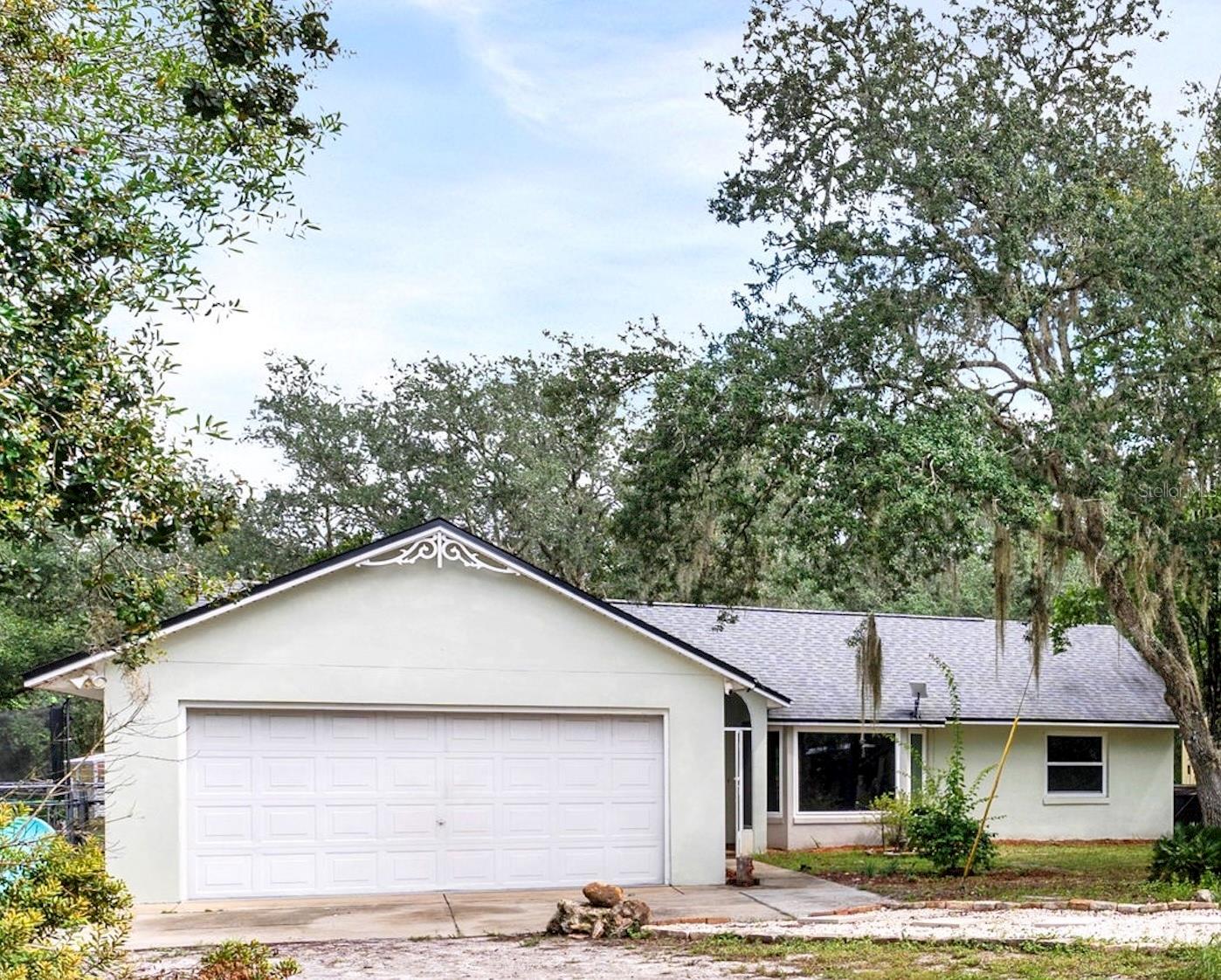 Welcome to 32645 Red Oak Dr in Eustis a not-so-average property offering the perfect blend of comfort, sustainability, and country living. Set on just over five acres with an additional five-acre parcel included, this retreat gives you more than ten acres of versatile land with partially cleared woods, nearby trails, and zoning that allows for horses and four-legged friends.
Inside, the three-bedroom, two-bath home features Corian countertops, 42-inch cabinets, and all new double-paned, insulated windows for maximum energy efficiency. The living spaces are cozy yet functional, highlighted by a wood-burning fireplace and a screened lanai with handmade pavers that make it easy to relax year-round. Upgrades include 200 amps to the electrical system, water heater 2023, septic extension and pumped in 2024, and water filtration added to the well in 2023.
The property is loaded with unique features including a greenhouse for microgreens, three USDA-approved irrigation tunnels with screens and completed irrigation, and a solar-powered system with Mango battery that powers the entire home. SELLER WILL PAY OFF AT TIME OF CLOSING. You'll also enjoy a gazebo and outdoor shower for peaceful retreats, an RV can be hooked up directly connected to the home, and a separate two-car garage with loft above for storage or workshop space. The air-conditioned shed with electricity provides additional room for hobbies or projects, while the chicken coop and fenced area are perfect for animals.
This thoughtfully designed property balances country charm with modern convenience. Whether you?re looking to homestead, create a sustainable lifestyle, or simply enjoy wide-open space, this home offers it all?while keeping you just minutes from the Lower Wekiva River Preserve, Ocala National Forest, and charming downtown Deland. 32645 Red Oak Dr isn't just a home it's a lifestyle.