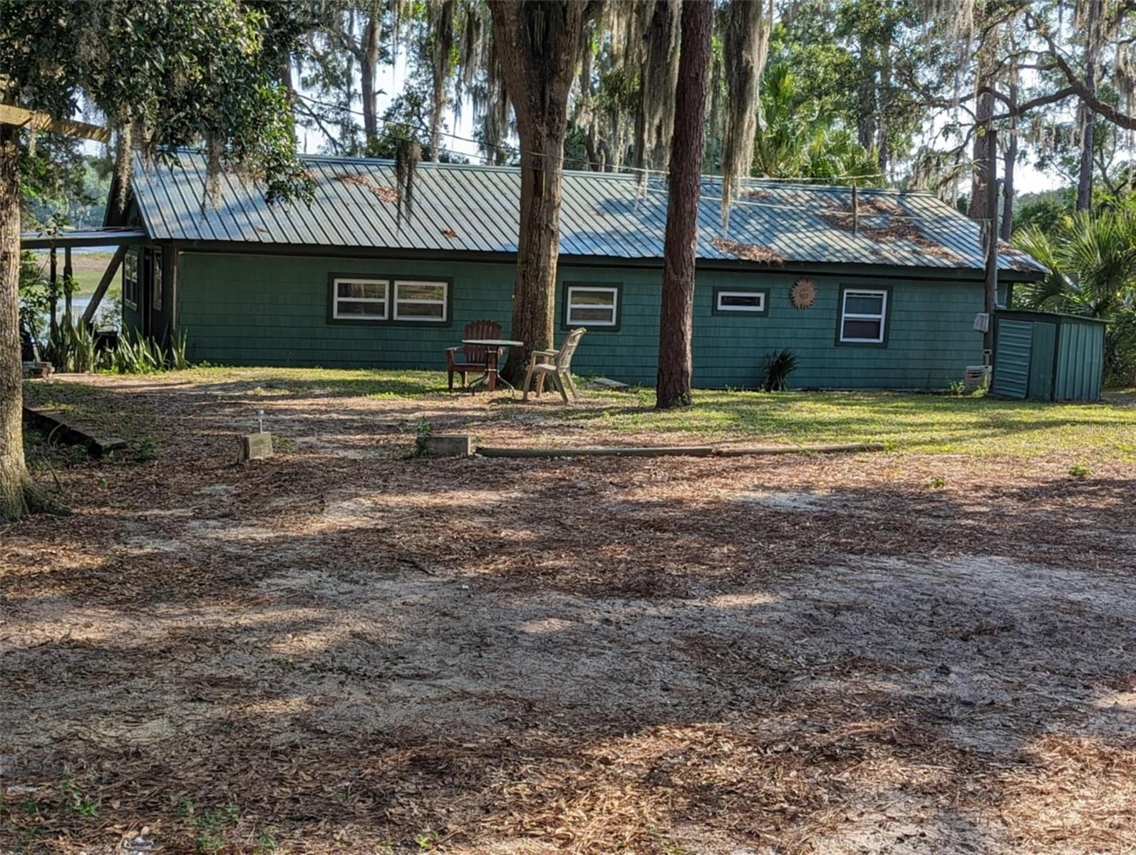 Lakefront Living in the Ocala National Forest! Escape to peace and privacy on this charming corner-lot retreat nestled along the serene shores of Wash Pond Lake. This 2 bedroom, 1 bath home offers everything you need for weekend getaways or full time living surrounded by nature. There is also an office/flex space right off of the master bedroom, offering extra space for whatever you may need. This home has been well cared for and you can feel the love as you enter the home. Enjoy tranquil mornings from your own boathouse and dock, perfect for kayaking, canoeing, or simply soaking in the beauty of the water right outside your front door. A metal roof was installed 10 years ago, new well pump (deep well) and updated electrical in 2011 provides peace of mind, while laminate flooring and carpet throughout make the home cozy and low maintenance. Curl up next to the cozy fireplace in the family room on those chilly Florida nights.
Step outside to an above ground pool, chain link fenced yard, all while sitting within the heart of the Ocala National Forest-a true outdoor lover's paradise. Whether you're casting a line, paddling around the lake, or enjoying the abundant wildlife, this property is made for those who crave simplicity and natural beauty. This home is one you have to see to truly appreciate-schedule your showing today and see for yourself.