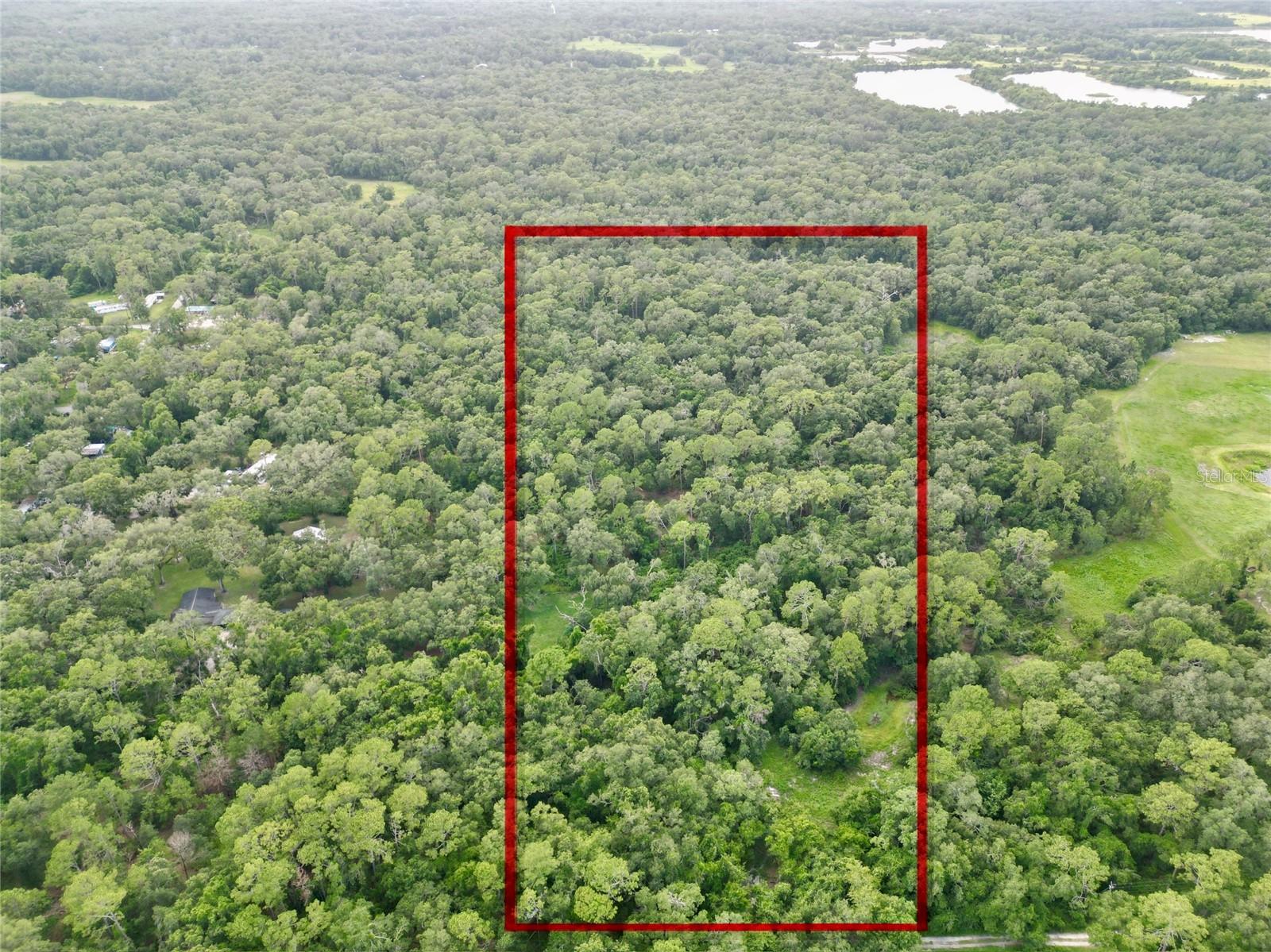Escape to nature with this 20-acre parcel of land. No filter needed here. This is raw, native, Florida beauty. We aren’t always palm trees and flamingos. We are rural, hometown, back roads, oak trees, and a slice of the simple life. Nestled approximately a half mile away from the main road. If you've ever dreamed of building your own secluded retreat, this is your opportunity to turn that dream into a reality. This property is covered in mature trees, palmettos and a seasonal pond, offering a peaceful and private environment. There is a 4” deep well that was installed in the 1970s, however, it has never been used. With ample space to roam, you can design and build your dream home. Cut out your own slice of heaven on earth. Tucked away from the main road, you'll enjoy privacy and tranquility, yet remain conveniently accessible to essential amenities. A short drive to The Villages, you'll have easy access to shopping, dining, and entertainment options. Enjoy quick and convenient access to I-75, making it a breeze to travel to neighboring cities and attractions in Ocala, Tampa, and Orlando. Explore the best of Florida while returning to your own corner of the world. This unique 20-acre woodland haven is a rare find, offering endless possibilities. Whether you're looking to build your forever home or a weekend getaway, this property is a blank canvas for your dreams. The owner has cleared the entrance and a portion beyond, for easier access and a path to get started! Don’t delay. Owner has priced to sell. Call today.