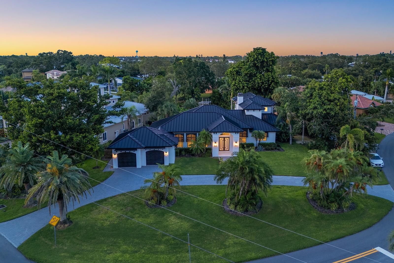Fully renovated British West Indies–style waterfront estate in the Coral Cove Community, where homes rarely come to market. Situated on a 0.59-acre corner lot across from the private neighborhood park and boat launch, this elevated residence offers peace of mind with NO flooding during recent hurricanes. Spanning over 5,000 sq. ft., the home was extensively renovated from 1999–2004 and again in 2023–2024, giving it an effective year built of 2009. Featuring 4 bedrooms and 3.5 baths, including dual primary suites on both floors, this property is designed for comfort and flexibility. The upper-level primary suite includes a spa-style bathroom with a freestanding tub, dual vanities, walk-in shower, and an oversized custom closet. The heart of the home is the chef’s kitchen, showcasing Café Series appliances, fluted designer range hood, Dolomite countertops, soft-close cabinetry, a waterfall-edge peninsula, and walk-in pantry. Seamless indoor-outdoor living is achieved through French doors opening to the pool, limestone deck, lush lawn, and a new dock with floating jet ski pad. Additional upgrades include impact-rated windows and doors, a new metal roof, two fireplaces, solid core interior doors, engineered hardwood flooring, and custom organized closets. Located just minutes from Siesta Key beaches, shopping, dining, and Sarasota’s cultural arts scene, this home offers the ultimate West of Trail lifestyle.