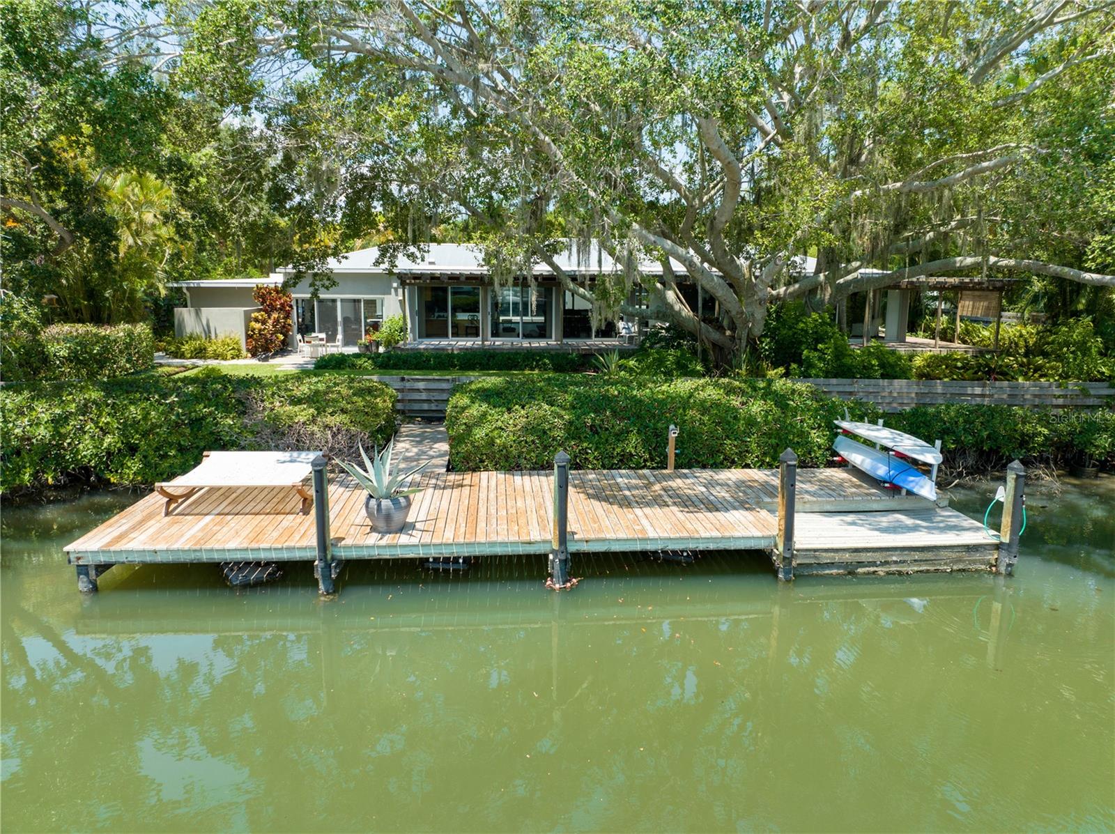 Waterfront Pool Home with Private Dock and Beach Access. Conveniently located on the North side of Siesta Key and completely updated by Siebert Architects & Pat Ball Construction. This property contains a 2 bedroom/ 2 bath Main House, with open floor plan, custom solid cherry wood kitchen cabinets, stainless steel counters and appliances, Bonus workout room/office and 2 car tandem garage parking. The Spacious Primary Suite, has views of the water, large custom walk in closet, primary bath with walk in shower, separate large whirlpool style tub and plenty of storage. The living room has panoramic water views, TV viewing area, and custom cabinetry. The guest bedroom overlooks the pool area and has full bath with walk in shower. The Guest House: Contains 1 bedroom /1 bath, large living area, Kitchenette with marble countertop, stainless under counter refrigerator, sink, cooktop, full bath with walk in shower, and a large bedroom with garden and pool views. Common to Both Homes are tiled floors, impact windows and doors, on demand hot water, water purification systems, updated plumbing, metal roofs and new AC units. The Exterior of the property features: Gated entry with fully a fenced in yard, 40 ft dock with easy access to the Intracoastal waterway and out to the Gulf. Private screened in courtyard/lanai with a 30'x15' pool, Outdoor kitchen with custom concrete counter top, wood cabinets, stainless grill, and dining area. Expansive IPE wood deck overlooking Cocoanut Bayou, potting shed with stainless sink, storage shed, outdoor shower, large driveway, Private and nicely landscaped yard with outdoor lighting, fruit trees and waterside patio. This home is currently part of the Cocoanut Bayou Home Owners Association which is voluntary. If you choose to join the association, you must apply and members have access to the private beach located across the street on Higel Ave. If you are looking for that private waterfront home with a modernized mid-century feel that is simply beautiful, convenient to downtown Siesta Key and all that Sarasota has to offer, this home may be just right for you!