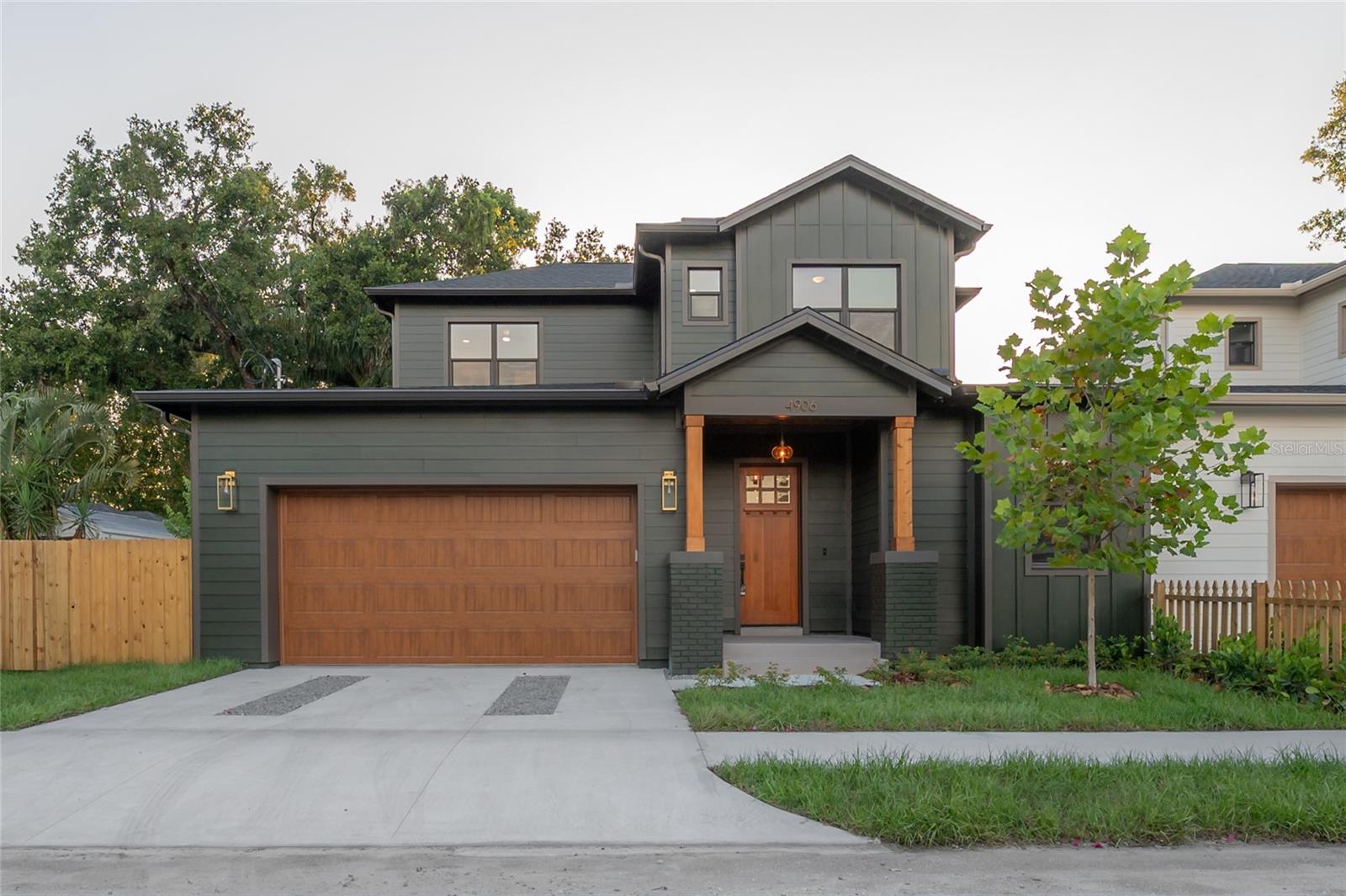 THIS. is. the. one. With moody deep green vibes on the outside and timeless, elegant, and cozy design on the inside, this home built by Seminole Heights local builder, 7 Pines Design + Build, doesn’t feel anything like your average new construction. It stands out not just because of its design-forward style, but because of its exceptional build quality—which translates into real value for you through energy efficiency that lowers monthly utility bills and thoughtful upgrades everywhere, so you can move right in without adding a thing.
Located on a corner lot in Southeast Seminole Heights, this is the only home of its kind in the neighborhood—a semi detached single-family residence that feels private and spacious. Inside, you’ll find four bedrooms, three bathrooms, and more than 2,100 square feet of living space filled with thoughtful details like soaring 10-foot ceilings, 8-foot solid-core doors, custom tile accents, and high end designer lighting throughout. The chef’s kitchen is the heart of the home, offering white quartz countertops on an oversized island, large pantry, an upgraded appliance package, and a dramatic, tiled custom vent hood that is surrounded by sleek black storage towers with brass accents. The downstairs living areas are open and spacious, and also offers a full bathroom and bedroom (perfect for a home office). The upstairs layout offers a laundry room conveniently located between the bedrooms; 2 guest bedrooms with reach-in closets and a full bathroom, as well as a spacious primary suite. The primary bedroom include dual walk-in closets, and the most luxurious and tastefully designed en suite bathroom with pearl-finished vertical tiles, glass enclosed shower, green and polished brass accents, and a separate water closet. A rare attached two-car garage adds convenience, while the fully fenced backyard with a covered porch provides the perfect outdoor space for entertaining, relaxing, or enjoying the Florida sunshine.
The behind the scenes of this home are just as impressive as the aesthetics. This home was designed with building science at its core, featuring impact Low-E windows, a high-efficiency heat pump water heater, and a variable-speed HVAC system with a whole-home dehumidifier and fresh air system—all chosen for comfort, durability, and long-term savings. Backed by a builder warranty, this one-of-a-kind Seminole Heights home is stylish, efficient, and truly built to last. Two units were built, and one has already sold pre-market! Don’t miss this rare opportunity to make this truly exceptional house your new Seminole Heights home. *Ask about the lender incentive of up to $5,000 for using preferred lender!*