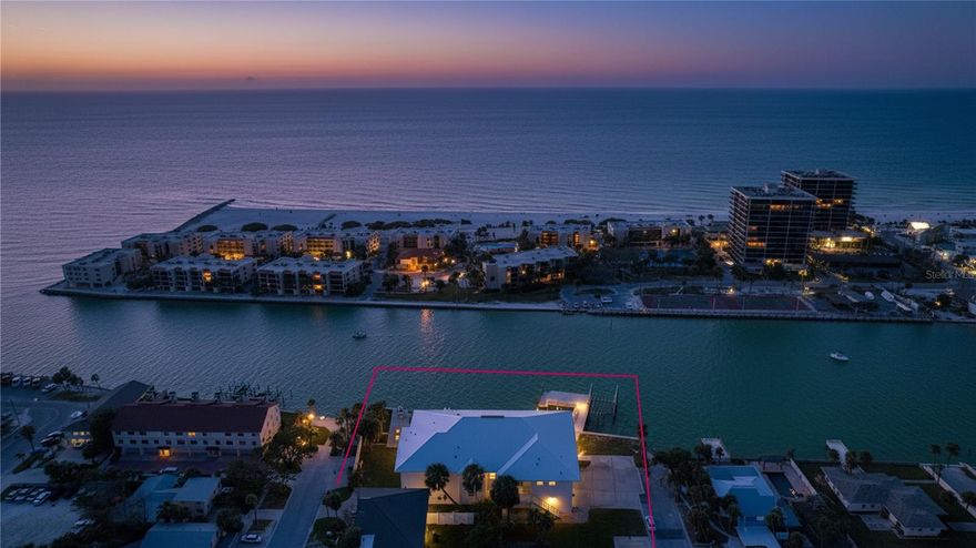 One or more photo(s) has been virtually staged. Extensively remodeled in 2023, this FEMA-compliant waterfront home sits on a rare combination of four platted lots—including deeded submerged land—offering approximately 164 feet of pristine Intracoastal frontage and an unrivaled west-facing vantage point toward Blind Pass and the Gulf. Recent upgrades include new shell-stone flooring throughout (even on the balcony), all-new impact windows, doors, and sliders to maximize the water views, new stucco siding, garage doors, HVAC (2025), a new dock with 13,000-lb boat lift, and a new pool. Elevated approximately 14 feet above sea level, the home combines timeless coastal design with modern features: an open great room with study or optional forth bedroom, a bright kitchen with island and double ovens, private elevator, and an expansive primary suite with a 15' × 17' walk-in closet and 12' × 12' bath. The ground-level area provides generous covered parking, workshop, and storage space. From this location you can literally see where the Gulf meets Blind Pass—one of the most dynamic and scenic boating corridors on the island—offering front-row views of yachts, fishing boats, and sunset cruises passing by. This is also a prime spot for fishing, as sea life gathers at the mouth of the pass before entering the channels. Situated just across from newly renourished beaches and within minutes of Corey Avenue’s shops and restaurants, this home offers a rare blend of elevation, open-water orientation, and boating lifestyle that defines the best of St. Pete Beach.