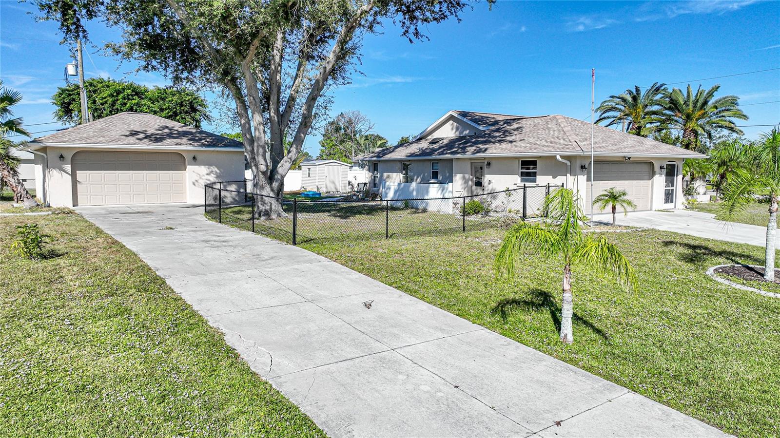 Located just 6 miles from Englewood Beach, this 2-bedroom, 2-bathroom home offers 1,661 sq. ft. of living space on a spacious 0.40-acre corner lot. Surrounded by mature oak, palm trees and winding walkways, the property features two charming storage sheds, a screened outdoor living space, and two garages with a combined 1,098 sq. ft. of garage space. The rear screened lanai spans 388 sq. ft., providing a private retreat, while an enclosed Florida sunroom with large windows offers year-round enjoyment of the lush surroundings.
Significant updates have been made, including an A/C system (2021), re-piping (2018), water heater (2018), and exterior paint (2020). The second garage, built in 2006, measures 672 sq. ft. and features its own 220-amp electrical panel, storm-rated door, A/C unit, attic insulation, and a 1,175 sq. ft. driveway—perfect for oversized RVs, boats, trailers, or a car collection.
Inside, the kitchen boasts solid wood cabinets, a tasteful tiled backsplash, and Silestone Quartz countertops. The home’s interior is finished with wood laminate and tile flooring, oversized windows, and a skylight that fills the space with natural light. Thoughtful architectural touches, such as a sash window at the end of the hallway, encourage the flow of subtropical breezes throughout the home.
Located in an X-flood zone, this property typically does not require flood insurance, offering additional peace of mind. Sidewalks in the neighborhood connect to local parks, shops, and the beach, creating convenient access for walking, jogging, or biking. With its combination of comfort, functionality, and coastal convenience, this home is ready for its next owner.