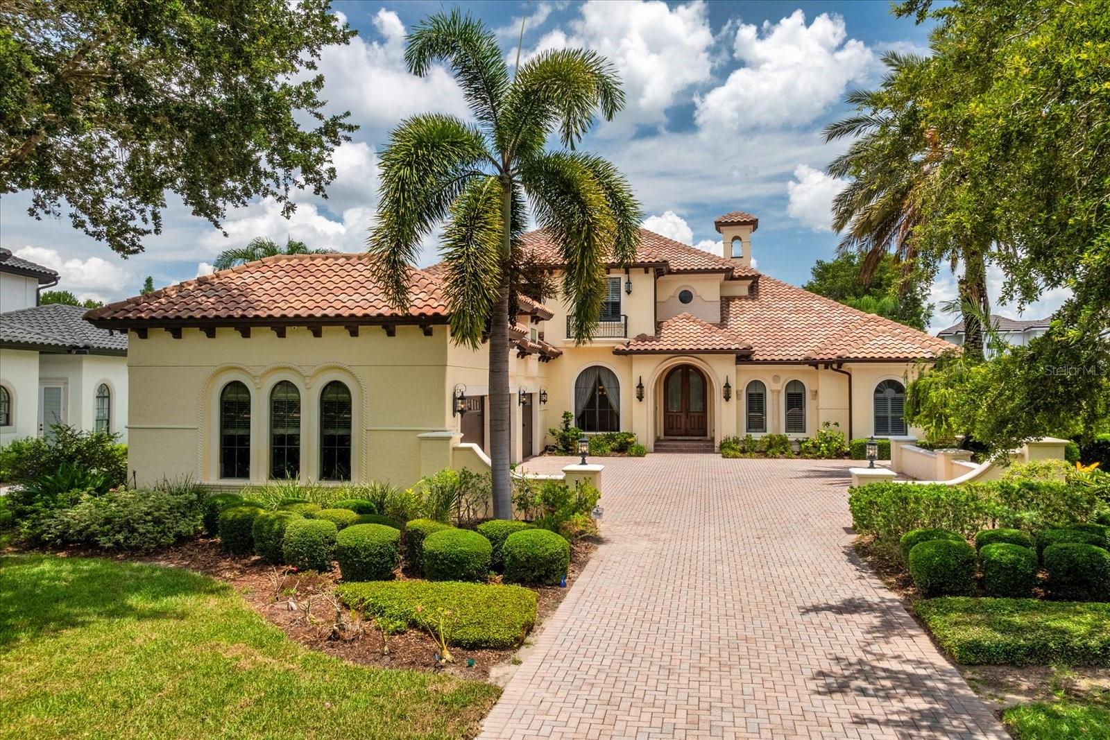 Welcome to 9253 Tibet Pointe Circle in the beautiful 24-hour gated/guarded community of Keene's Pointe in Windermere, Florida. This JR Watson custom-built mediterranean style home located on over 224 feet of lake frontage on Lake Tibet of the Butler Chain of Lakes, offers a functional and spacious floor plan to accommodate any buyer. Entering the drive up to the courtyard is a 4-car garage and inviting entrance with wood and glass arched doors. The formal living room with gas fireplace and private dining room pave the way to the kitchen with large breakfast bar, island, walk-in pantry and high end appliances, overlooking the great room with wood beamed ceiling and sliding pocket doors, as well as a wet bar, wine cellar and spacious laundry and mud area. On the other side is the private primary suite with large walk-in closet and spacious primary bath, as well as a functional office with built-ins and wood beamed ceiling. The second floor boasts a bonus area half way up the wood and iron staircase, perfect as a media or exercise room or additional office or hobby room. At the top of the stairs is an open area with built-in desks for study time, three spacious en-suite bedrooms and a game room with wet bar that opens up to the balcony overlooking the back yard and lake. Perfect for entertaining the 10 ft. multi slide pocket doors in the family room open up to the lanai to create a seamless transition between indoor and outdoor space to the outdoor lanai large enough for another complete living area with summer kitchen and its own gas fireplace overlooking the pool with rock waterfall and spa. Just outside the screened enclosure is the fire pit with an abundance of seating, fenced back yard and walk way to the boat dock. This home boasts 12 ft. ceiling throughout with exquisite architectural details, and has been lovingly attended to with new sod, new pool equipment, smart home features such as Sonos, Lutron lighting, My Q, smart thermostats, security and camera systems, updated AC units, newer Sub Zero and Wolf appliances, hardwood flooring, plantation shutters, and much more! Priced to sell, call today for your private viewing.