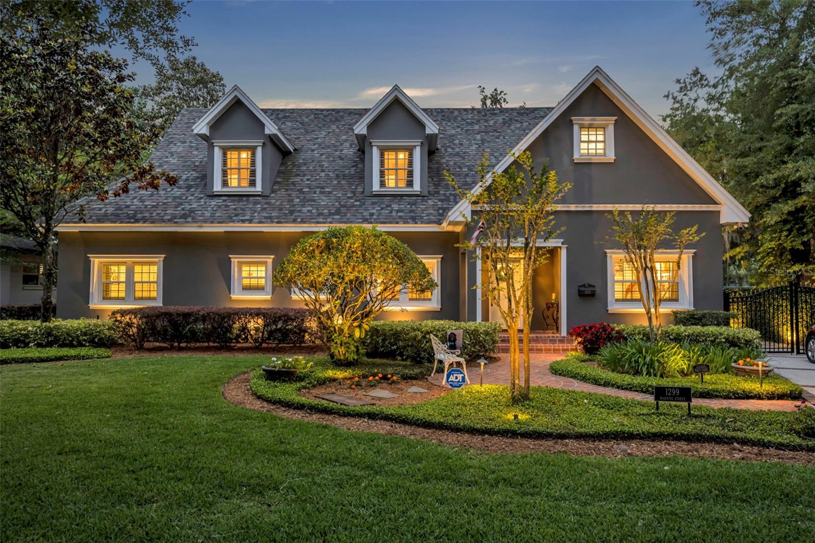 Welcome to your private slice of paradise—a beautifully renovated home with a brand new 2024 pied-à-terre guest retreat, nestled just steps from the iconic Kraft Azalea Garden on the shores of Lake Maitland, and walking distance to the renowned boutiques and dining of Park Avenue. Positioned on a beautiful 0.30-acre lot, this residence is enveloped with manicured landscaping, meandering brick pathways, and outdoor living spaces designed for effortless entertaining. This home captivates with exceptional curb appeal—complete with vibrant florals, a stately new blue front door, and architectural charm. The total square footage is 3784sf with the main home 5 bedrooms/4 bathrooms and 3304sf; the guest retreat is 1 bedroom/1 bathroom with 480sf. Recent updates include new flooring, fresh interior and exterior paint, a renovated kitchen, three new bathroom renovations, almost all new windows, and numerous decorative touches like new crown molding and plantation shutters. The heart of the home features a spacious open-concept layout ideal for entertaining. The living room with an updated gas fireplace flows into the kitchen, which boasts new Bosch appliances, bar seating, a walk-in pantry, and a charming picture window with garden views. The elegant dining space, with 11-foot ceilings and a wall of windows, frames the picturesque backyard. The first floor offers three bedrooms and two full bathrooms, including an en-suite, as well as an office. The second floor includes two large bedroom suites with high ceilings and a laundry room. The upstairs luxurious primary suite impresses with a tray ceiling, cozy fireplace, dual walk-in closets, and a renovated bathroom with granite dual vanities, a freestanding soaking tub, and an oversized walk-in shower. The secondary suite includes its own walk-in closet, spacious bath with double vanities, and a large climate-controlled storage area for ultimate flexibility. Features include French doors, hardwood floors, custom built-ins, crown molding, and plantation shutters throughout. But the crown jewel of the property is the brand-new 2024 detached pied-à-terre—a versatile studio suite with a full bedroom and bathroom, a refreshment area, and a private balcony with tranquil views, ideal as a guest house, executive office, fitness studio, or artist’s retreat. Outdoor living is a dream with a screened brick patio beneath a beamed ceiling, a charming open-air terrace, an enchanting fountain, and complete privacy thanks to a 6-foot concrete wall surrounding the grounds. With ample space to add a custom pool, the possibilities are endless. Located just steps from the 5-acre Kraft Azalea Garden with lakefront trails and a fishing dock, and a short stroll to Park Avenue to enjoy a scenic boat tour or one of the many museums—this is a truly exceptional offering in one of Winter Park’s most sought-after enclaves.