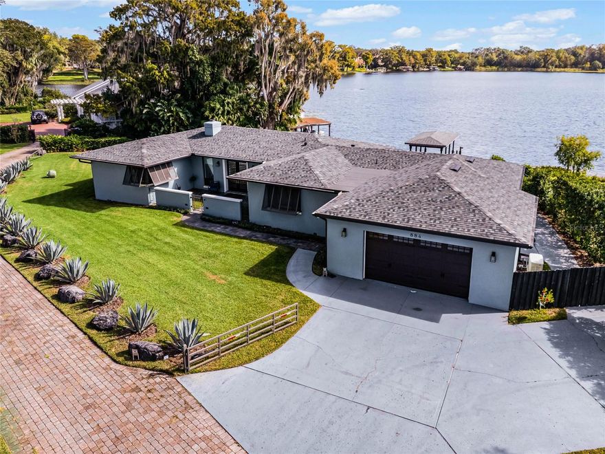 Discover an extraordinary opportunity to own a one-story lakefront retreat on the picturesque Lake Mizell, part of the coveted Winter Park Chain of Lakes. This stunning 4-bedroom, 4-bath home, completely remodeled in 2020, offers nearly 3,000 square feet of thoughtfully designed living space on a tranquil, half-acre lot. The tri-split floor plan ensures privacy and functionality, with walls of glass sliders and expansive picture windows that flood the home with natural light and showcase breathtaking lake views. Gleaming hardwood floors flow throughout, complementing the modern updates and timeless charm of this exceptional residence. The spacious primary suite is a serene oasis with unparalleled views of the lake, while the fourth bedroom serves as a secondary primary suite, featuring a large en-suite bath and an oversized walk-in closet, making it ideal for guests or multigenerational living. The gourmet kitchen, equipped with high-end appliances, a central island, and a walk-in pantry, is both a chef’s dream and a stylish gathering space. The living room, complete with a gas fireplace and custom built-ins, exudes warmth and comfort, and the dining area provides a stunning backdrop of the lake, perfect for unforgettable meals and entertaining. Step outside to experience true Florida lakefront living. The expansive back deck is an ideal space for relaxation or hosting, while the newer Trex deck and covered boat dock with lift offer seamless access to boating and water activities. Situated across Lake Mizell from the scenic Windsong Preserve, this home provides a sense of seclusion while remaining just a short stroll from the renowned shops and restaurants of Park Avenue in downtown Winter Park. This rare lakefront masterpiece combines unmatched views, modern updates, and an unbeatable location. Don’t miss the chance to make this slice of paradise your own — schedule your private showing today.