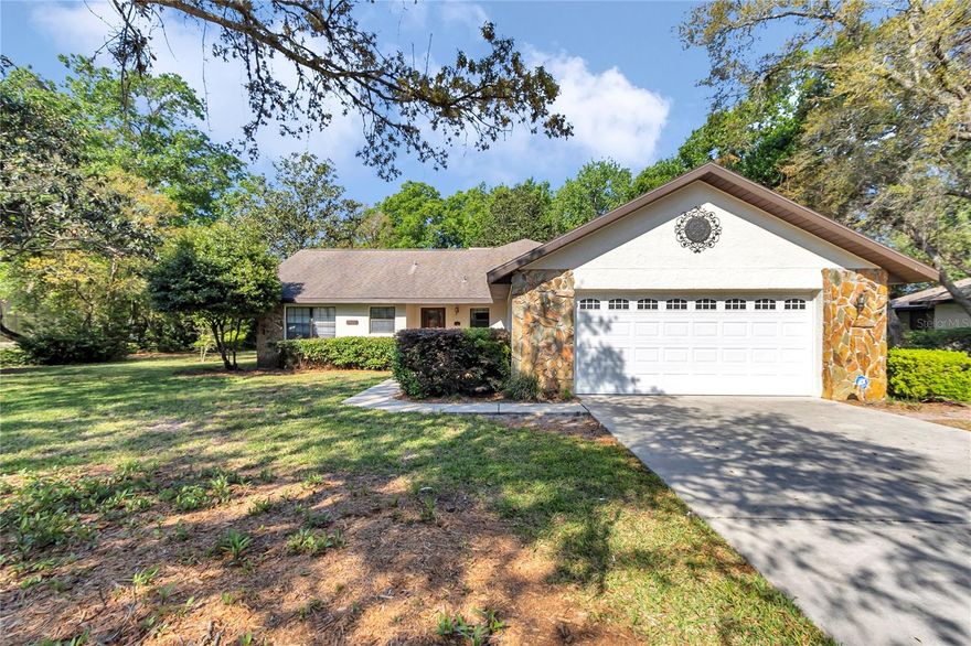 Tucked away on a spacious, beautifully treed lot in the established community of Majestic Oaks, this well-maintained 3-bedroom, 2-bath home offers the kind of space, privacy, and peaceful setting that so many buyers relocating to Ocala are looking for. From the moment you arrive, the long driveway, side-entry garage, mature landscaping, and charming stone accents create warm curb appeal and a welcoming first impression.

Inside, you’ll find a bright entry foyer leading into a large living area with soaring vaulted ceilings, abundant natural light, and a striking floor-to-ceiling stone fireplace that serves as the focal point of the room. The layout offers comfortable everyday living with generous gathering space, an open feel, and a separate dining or breakfast area just off the main living space. Large windows throughout bring in beautiful views of the surrounding greenery.

Out back, the home continues to impress with a screened porch and an additional patio area overlooking an oversized backyard shaded by mature trees. Whether you enjoy quiet mornings outdoors, room to garden, or simply appreciate extra privacy between neighbors, this homesite offers a rare amount of outdoor space and natural beauty. The side yard and rear yard provide flexibility for outdoor enjoyment, entertaining, or future personalization.

Additional features visible from the property include a single-story layout, spacious bedrooms, solid surface walkways and driveway, established hedging, and a tucked-away setting that feels private while still being convenient to shopping, dining, medical services, and everyday amenities. For buyers coming from out of town and looking for a home with character, generous lot size, and classic Florida charm, 8160 SW 53rd Ct is a standout opportunity.