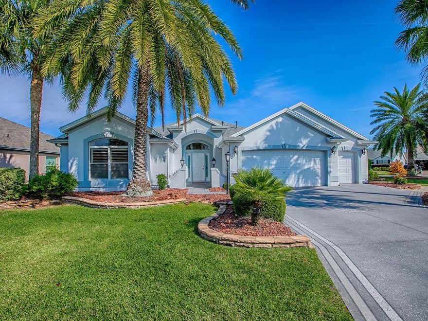 LOVELY 3 BEDROOM, 2 BATH LANTANA DESIGNER WITH GOLF CART GARAGE, SIDE ENCLOSED LANAI, AND PUTTING GREEN LOCATED ON A LARGE, PRIVATE CORNER LOT IN THE VILLAGE OF WINIFRED!  NEWER HVAC 2022 (surge protector added in 2024), NEW ROOF 2022, HWH 2010. This stunning home has lovely CURB APPEAL with custom landscaping around the entire home, and painted drive and walkway. You’ll find DIAGONAL TILE throughout the home excluding the bedrooms, ROUNDED CORNERS, and KNOCKDOWN CEILINGS – (NO POPCORN), and PLANTATION SHUTTERS! The upgraded kitchen offers GRANITE COUNTERTOPS, and NEWER BLACK STAINLESS APPLIANCES with a natural GAS stove, lovely light cherry cabinetry, CLOSET PANTRY, and a breakfast bar! The casual dining area opens with FRENCH DOORS out to the enclosed lanai. This light and bright room will become your favorite place with a great view of the lovely landscaped side yard, and a door that opens out to a PAVERED PATIO and a PUTTING GREEN! This corner lot offers so much desired PRIVACY! All 3 bedrooms have carpet and vaulted ceilings, ceiling fans, and plantation shutters. The primary bedroom has an EN-SUITE BATH with a large a WALK-IN CLOSET with BUILT-INS; GRANITE countertops, dual sinks, a vanity, a window, separate toilet room, and a FRAMELESS RAIN GLASS SHOWER DOOR on the updated tiled shower.  The spacious front guest room is being used as a den and office and both guest rooms have large closets! The guest bath has granite and lovely tiled shower with a FRAMELESS RAIN GLASS SHOWER DOOR with a custom valance.  The inside laundry room has added cabinets for extra storage, washer and dryer that do convey with the home, a folding counter, and a small refrigerator. The oversized 2 car + GOLF CART GARAGE has plenty of room for all your needs, pull down attic stairs, a sink, and a water filtration system. This is a well maintained, lovely home located in a The POPULAR VILLAGE of WINIFRED.  You’re close to LAKE SUMTER LANDING, ARNOLD PALMER LEGENDS COUNTRY CLUB offering 27 holes of golf, a pro shop, and driving range, and a beautiful restaurant with a spectacular view of the course. Recreation Centers close by as well as specialty grocery stores, dining, gas station, banks, all the conveniences within minutes. COME SEE ALL THIS LOVELY HOME HAS TO OFFER!